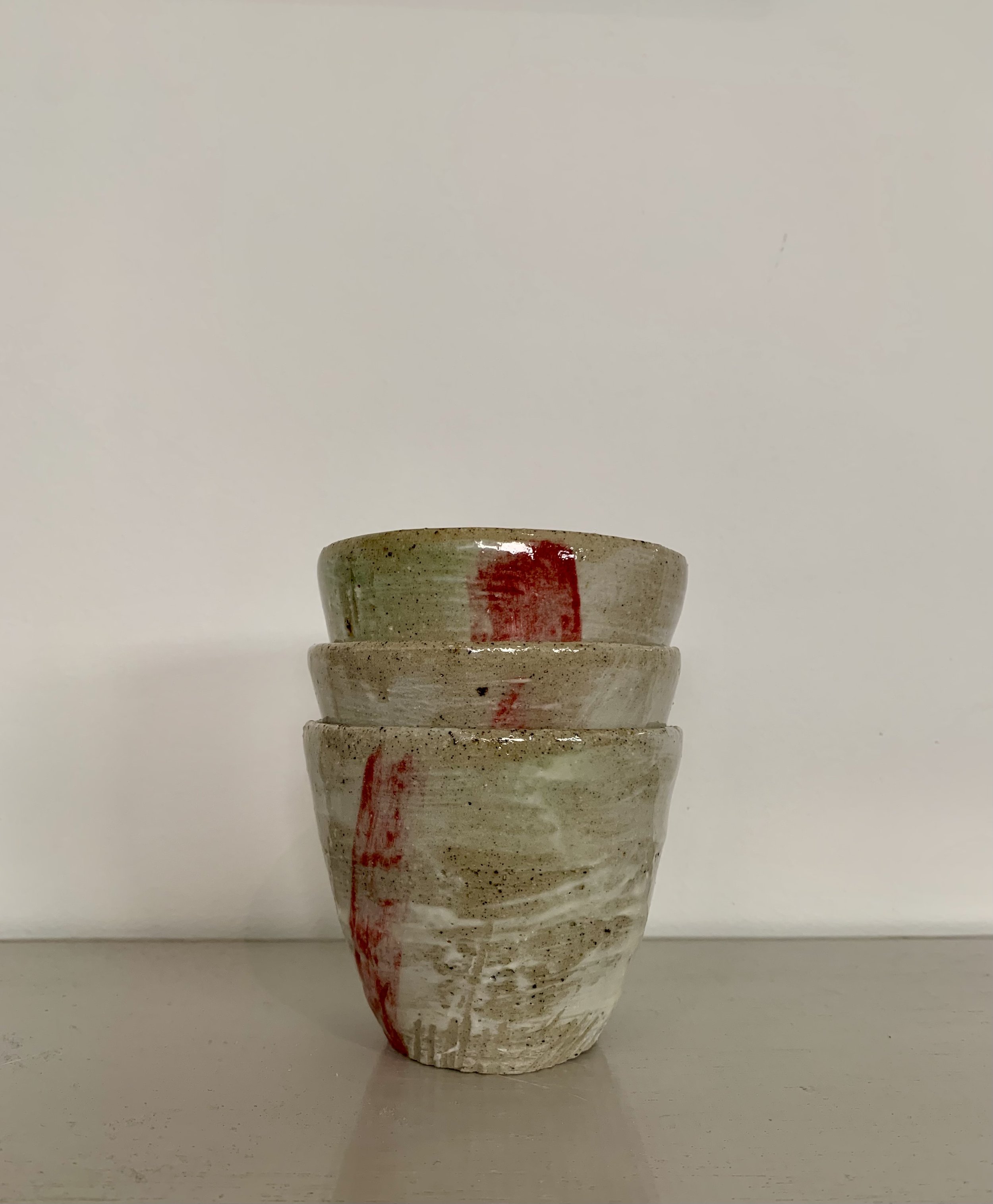 Three slip decorated and carved stoneware tumblers