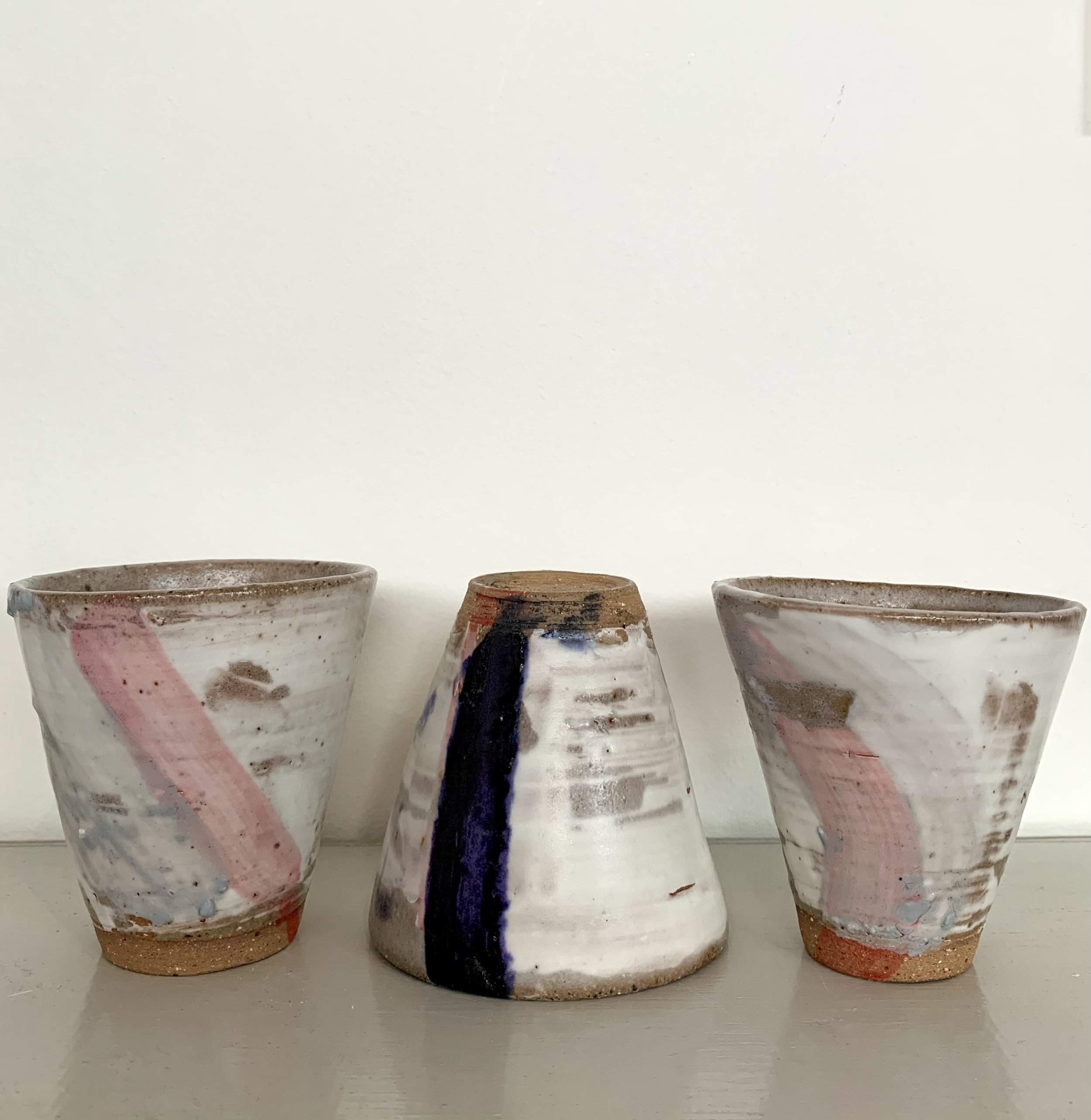 Three slip decorated stoneware tumblers