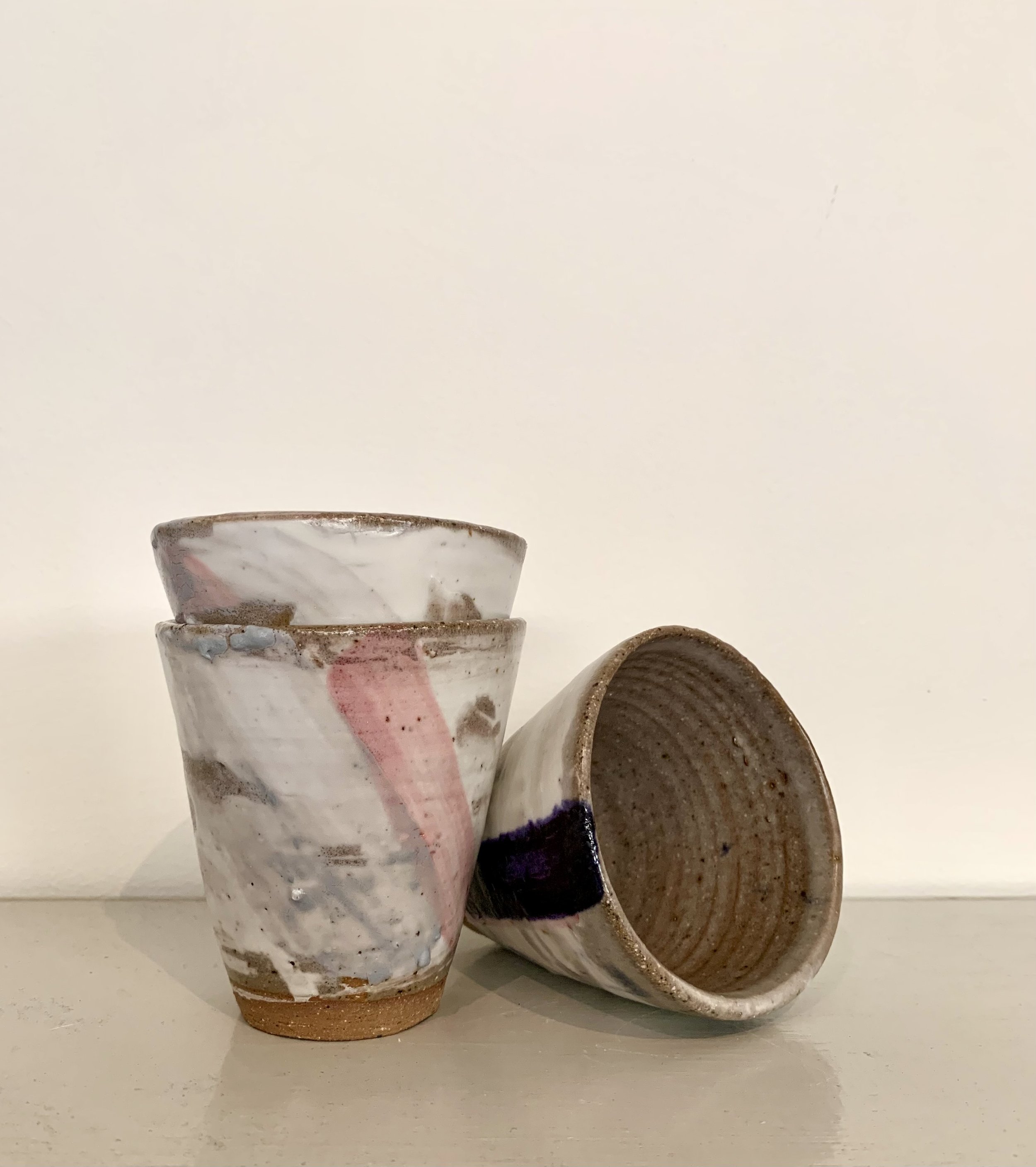 Three slip decorated stoneware tumblers