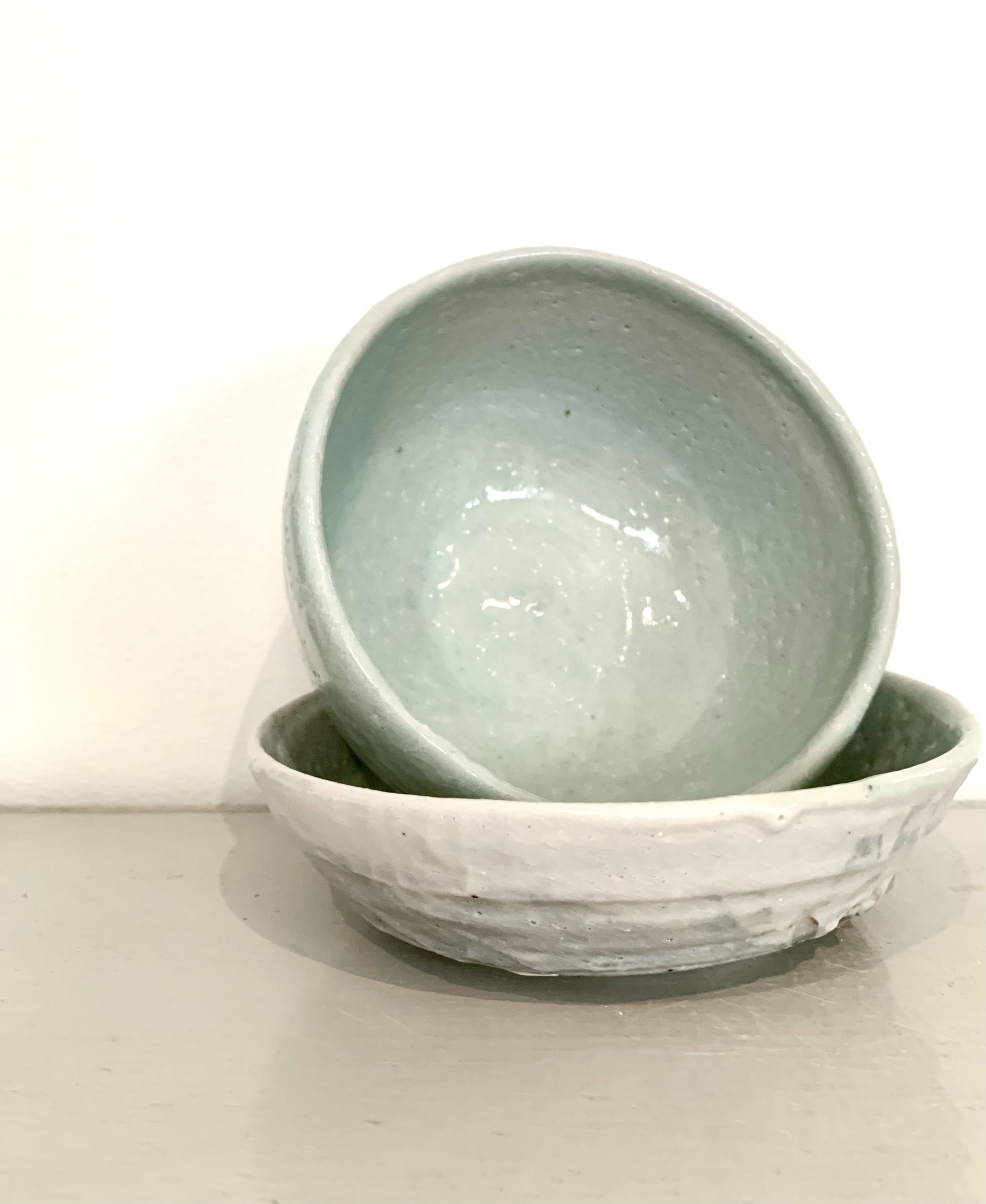 Two medium footed bowls, shino and ash glazed stoneware