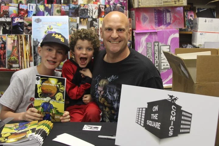 On The Square Comics Founder Jay Taylor and his kids at a store signing.