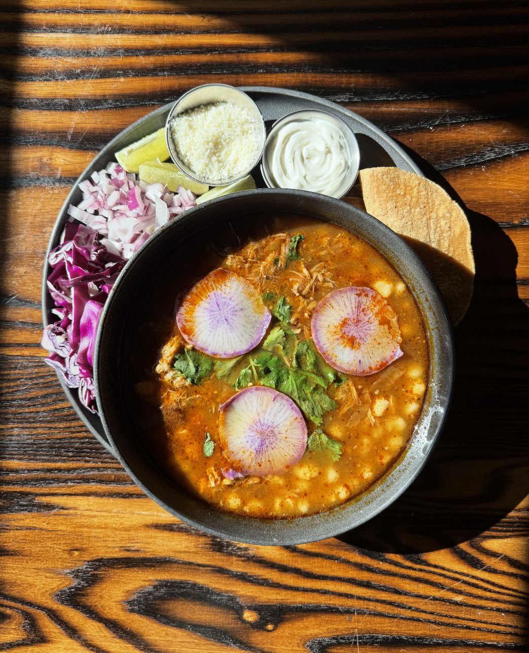 Pozole is back on the dinner menu. ⁠
⁠
Made from our own heritage pork, this stew is simmered with hominy and finished with shaved farm cabbage, radish, red onion, crema, and cotija. Served with corn tortillas.⁠
⁠
And because balance matters: finish 