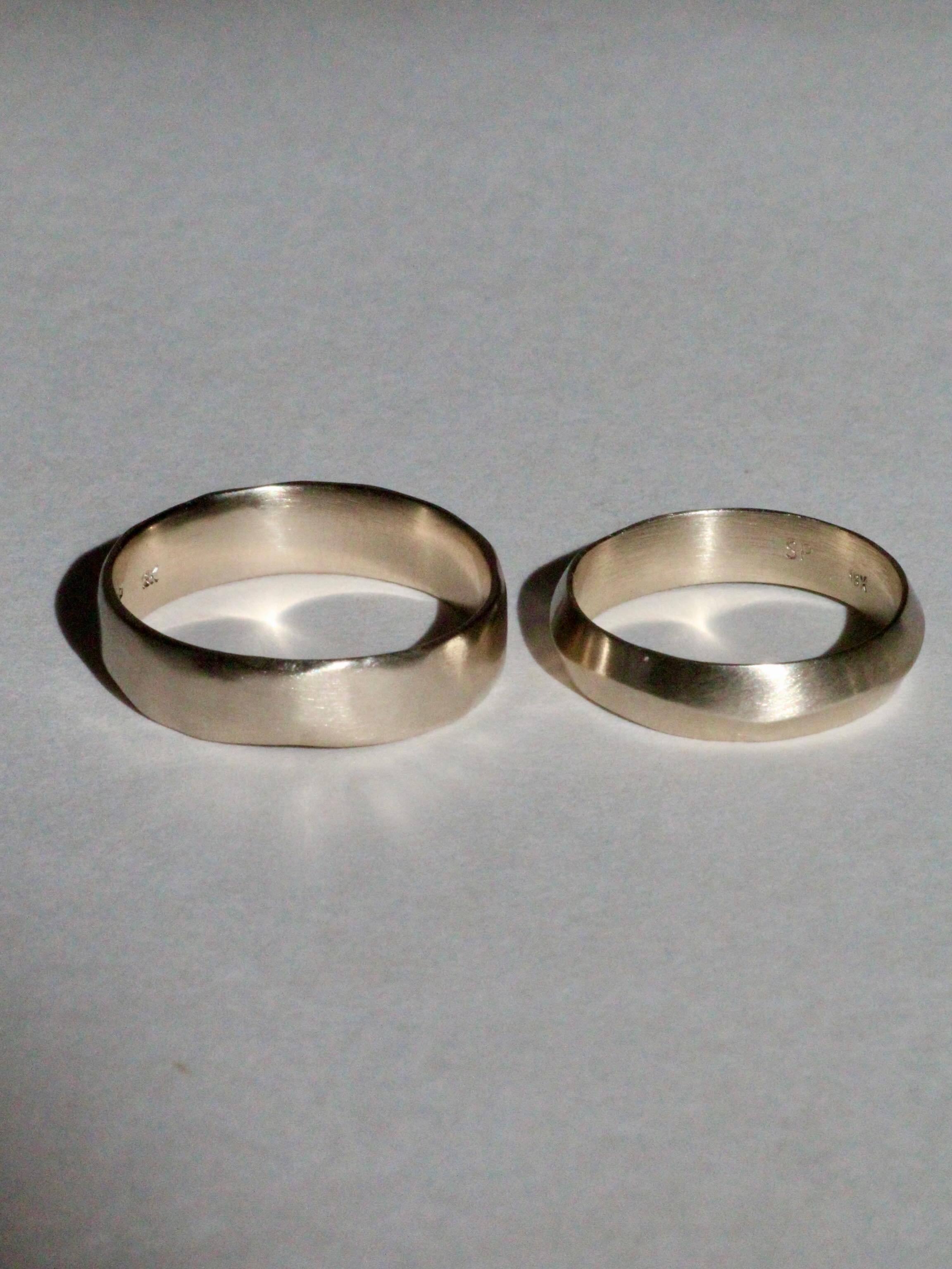 Custom commitment rings in 18k white gold for a couple who are not getting officially married, but wanted to celebrate their relationship and commitment to each other. 

One is a custom carved band with subtle facets and the other is my knife edge ba