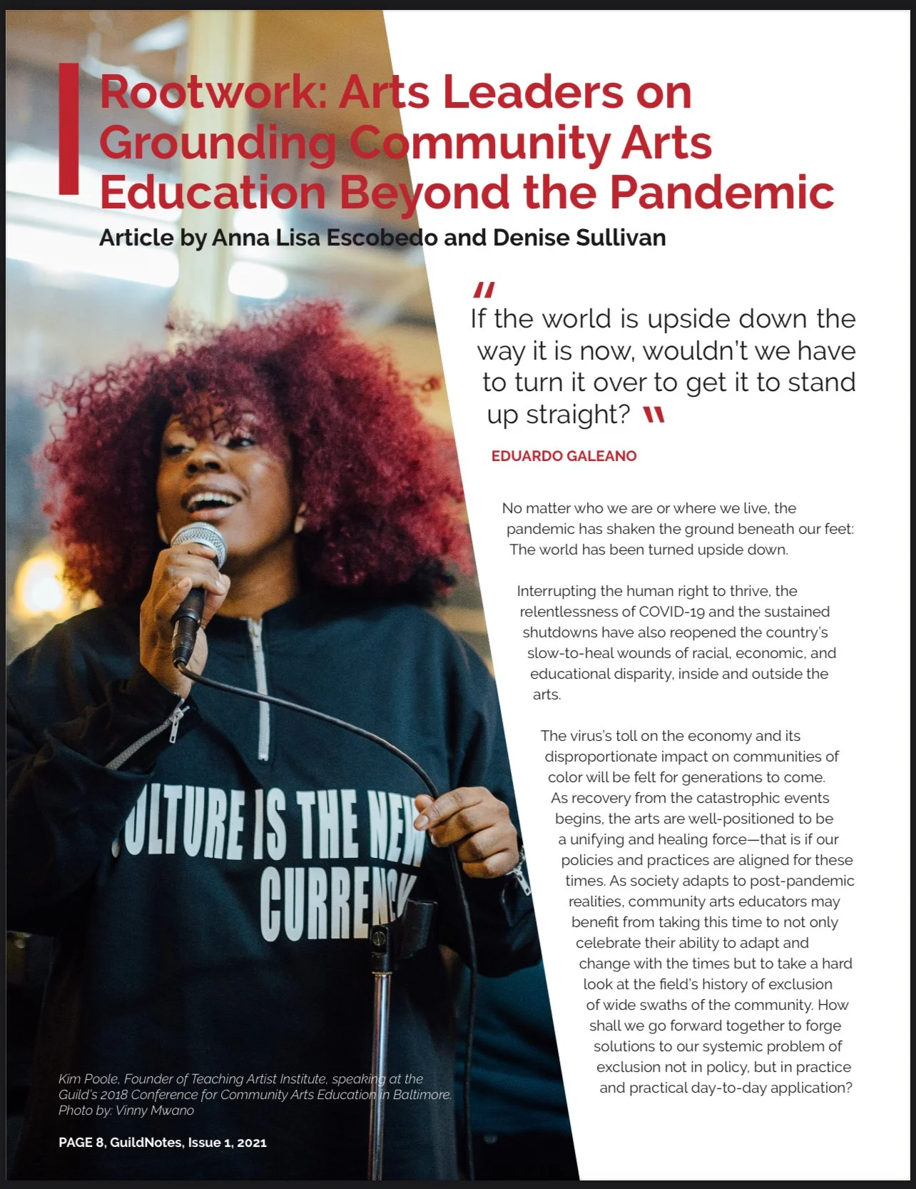 A woman with large red curly hair speaking into a microphone at a conference, wearing a black jacket and a shirt that says "CULTURE IS THE NEXT CURRENCY."