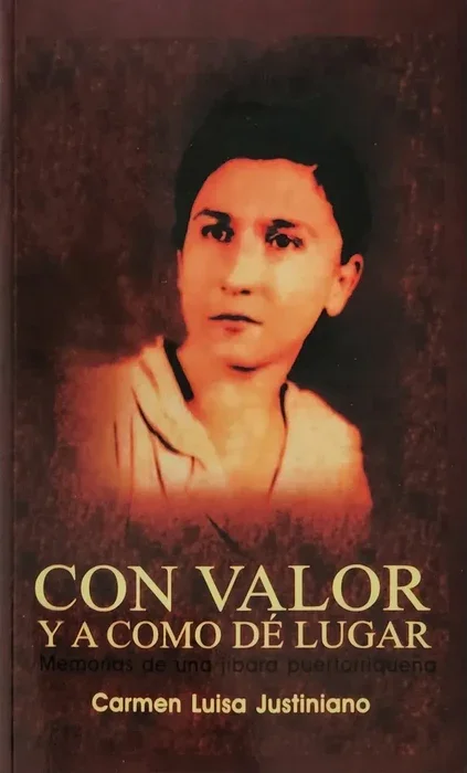 Book cover titled "Con Valor y A Como Dê Lugar" by Carmen Luisa Justiniano, featuring a portrait of a woman with short dark hair and wearing a light-colored top, set against a dark background.
