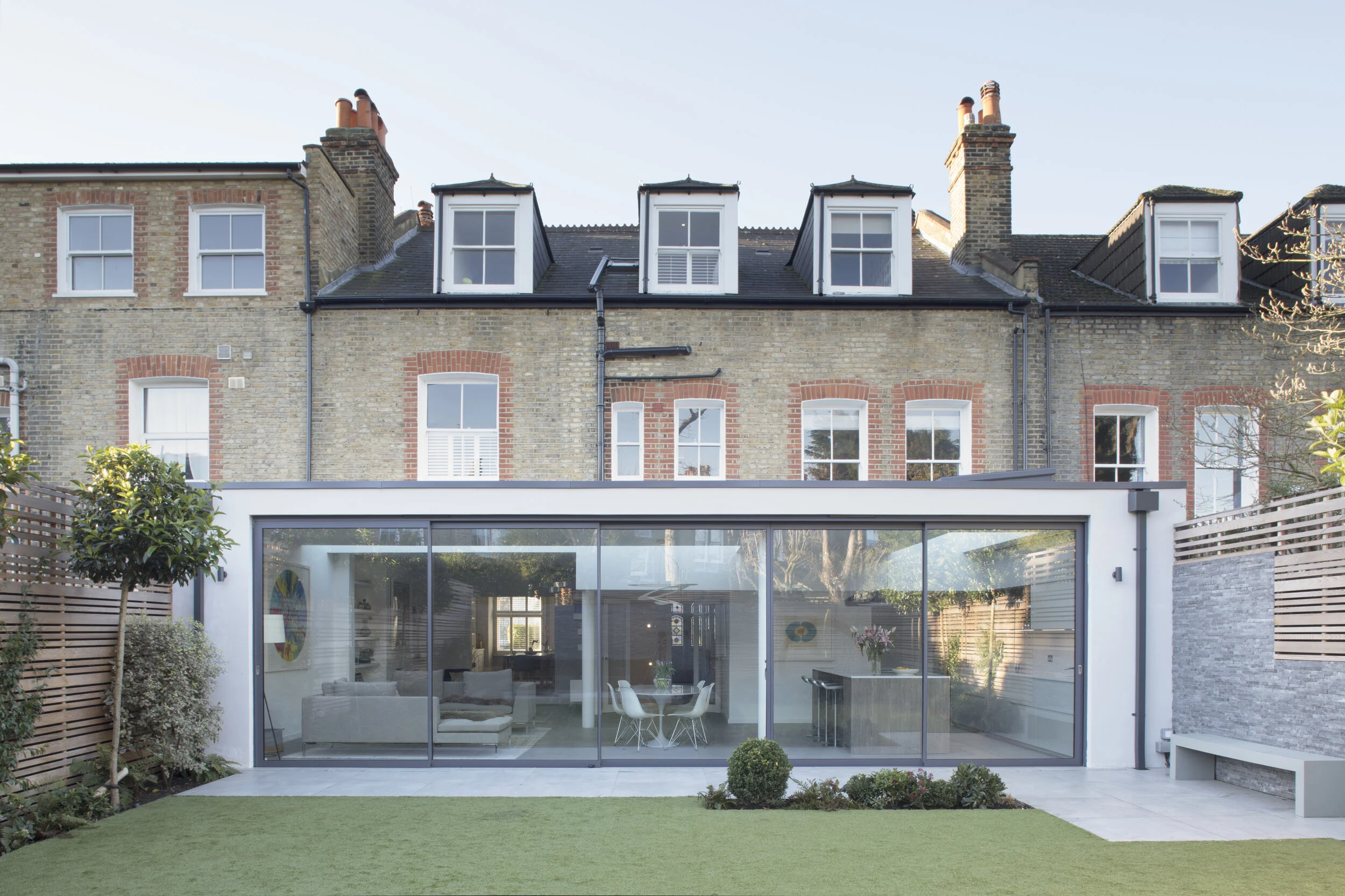 Rendered rear extension for terraced house in south London. Sliding glazed doors for extension.