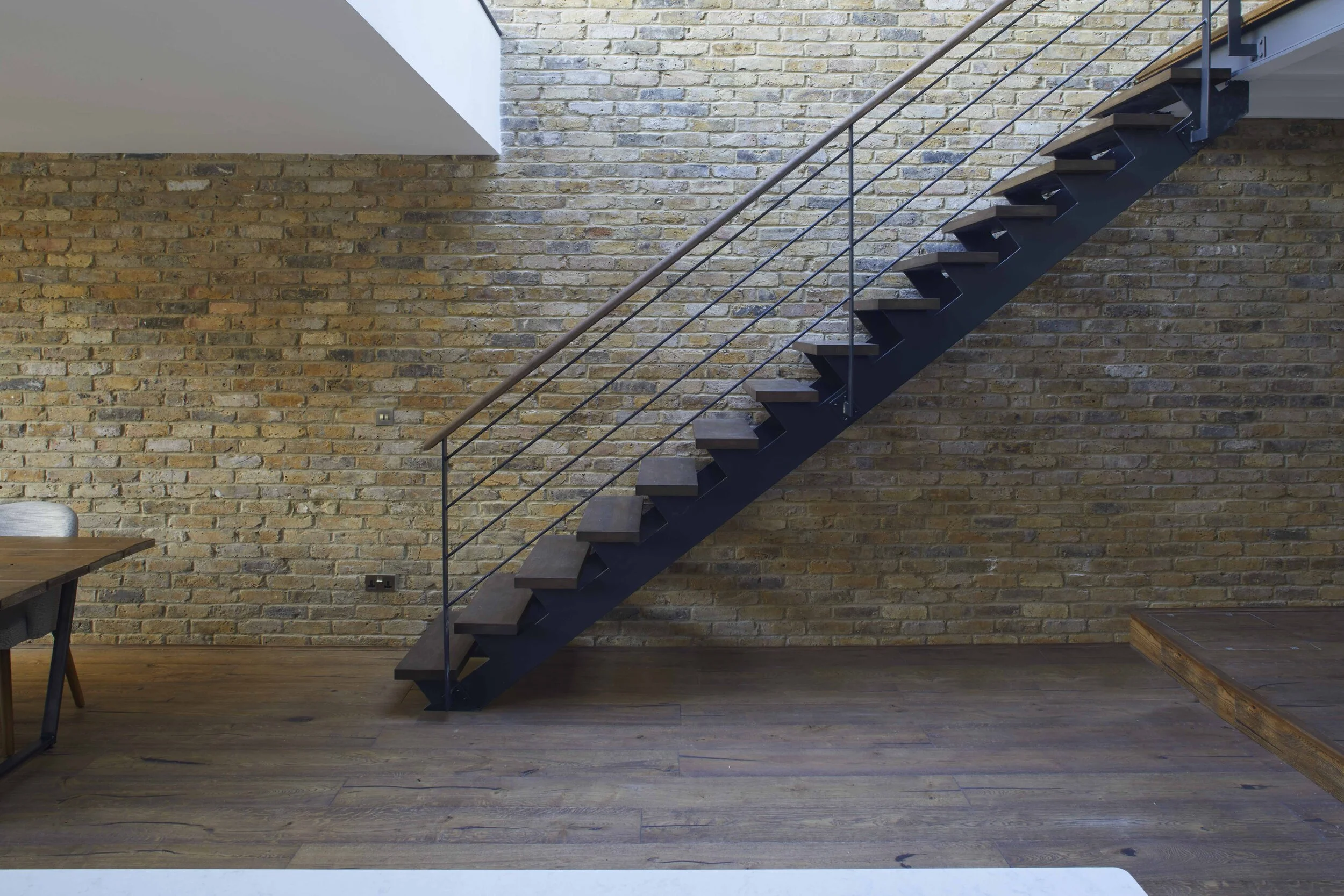 A simple modern staircase complements the original brickwork