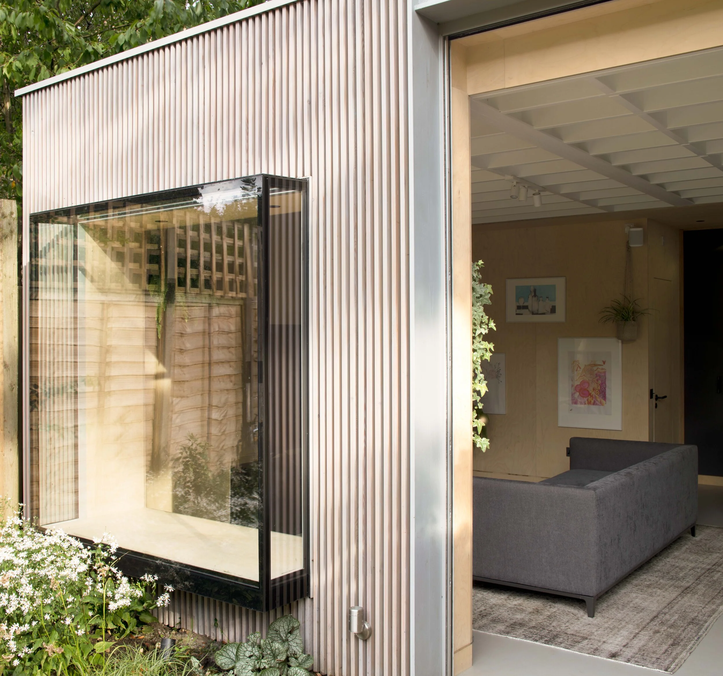 External shot of sliding doors and raw materials including timber in garden annex of london renovation from architects.