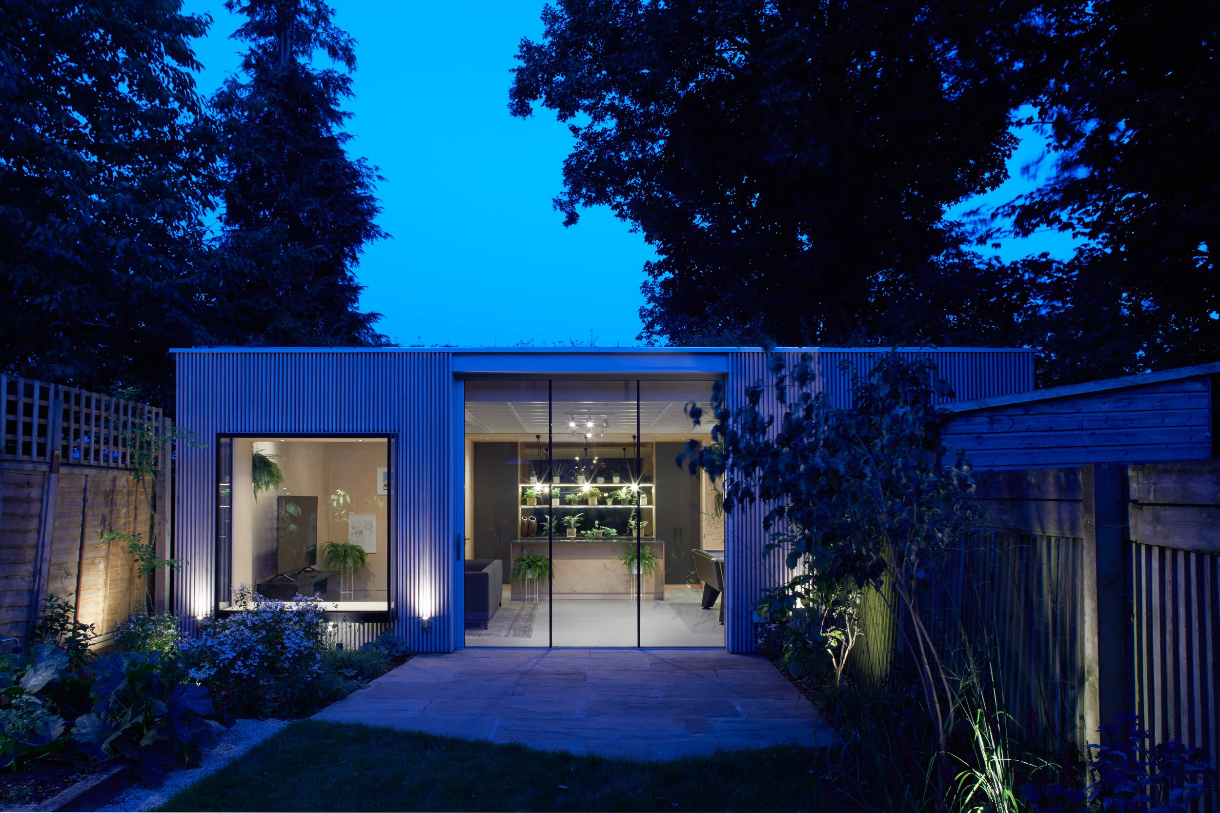 Night shot of timber based garden annex in London. Architects in London create inventive space.
