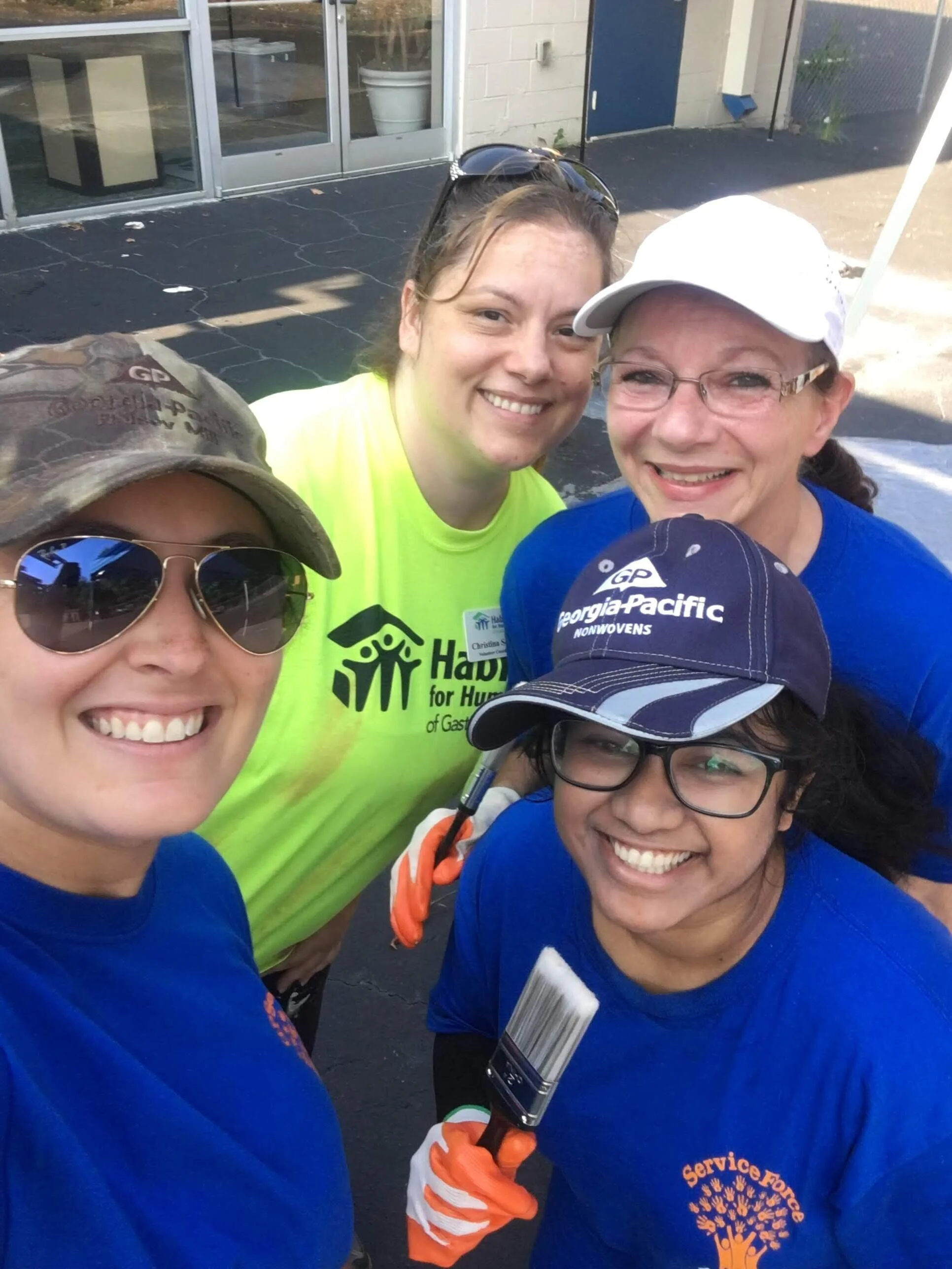 This image shows Nandita Gupta with other members from GP at Habitat for Humanity.