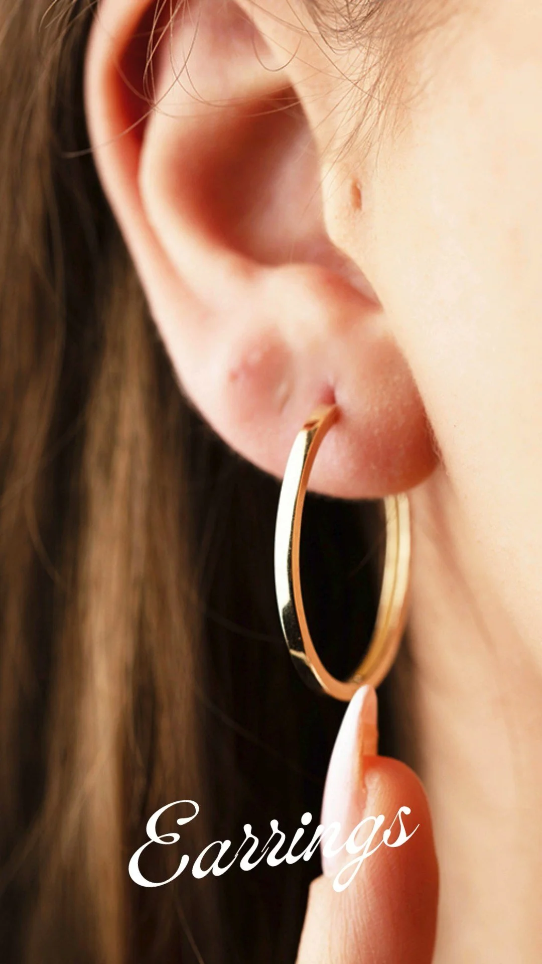 Close-up of a person's ear with a gold hoop earring being held by a finger, and the word 'Earrings' written in white cursive at the bottom.
