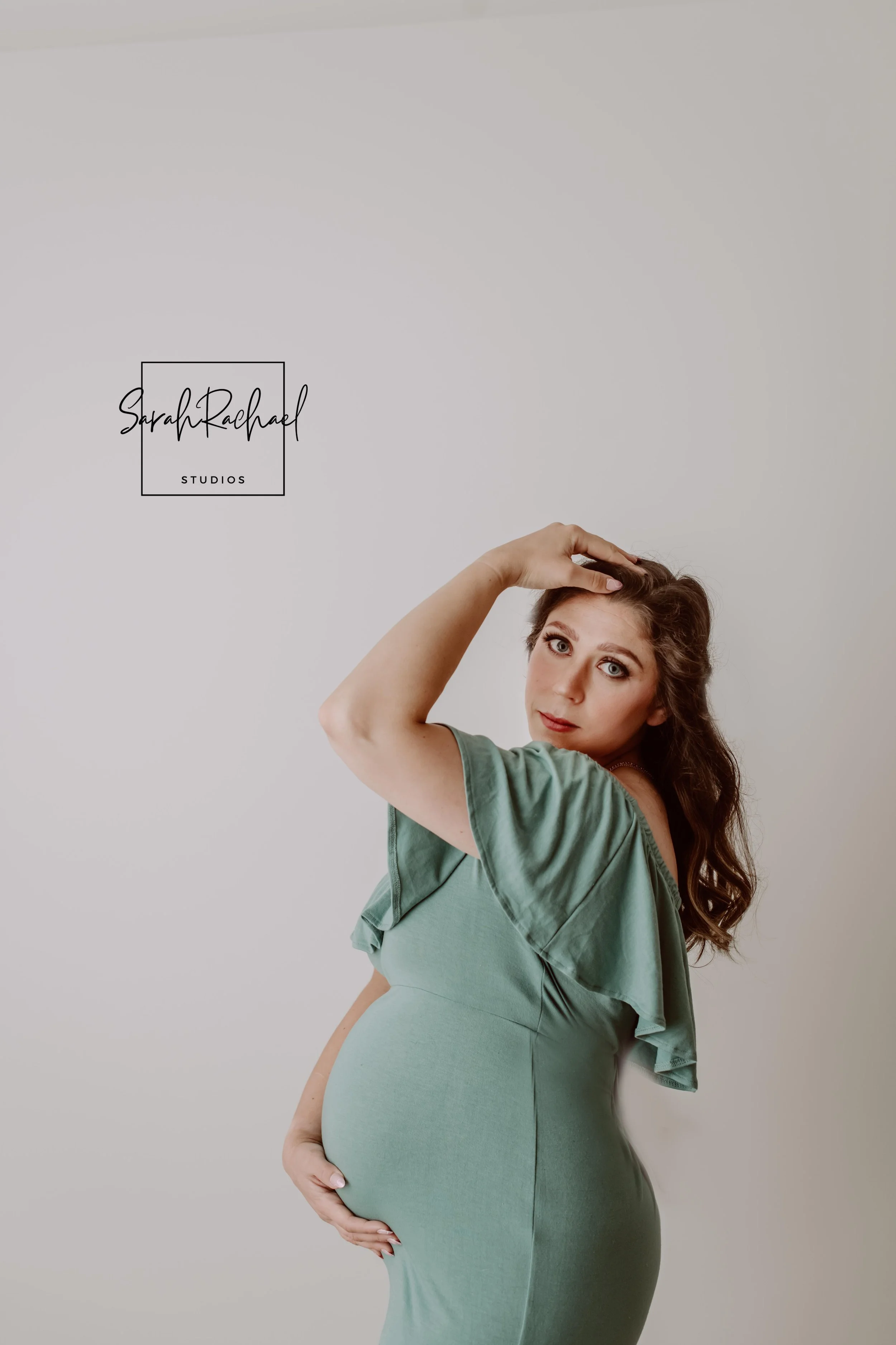 Studio maternity portrait of expecting mother wearing a flowing gown photographed by Sarah Rachael Photography in Maryland.