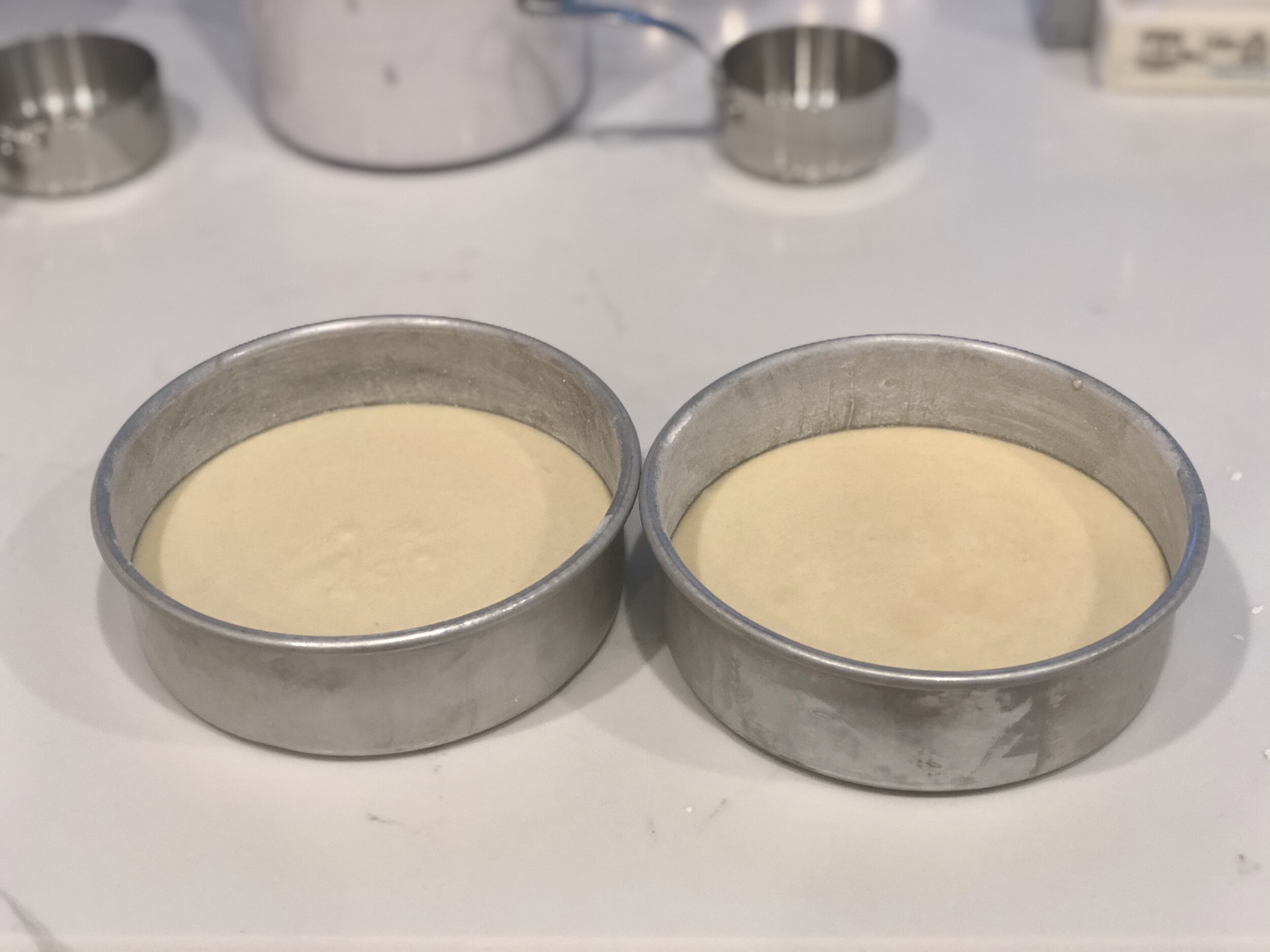  Tap pans on the counter to release air bubbles and even out the batter. 