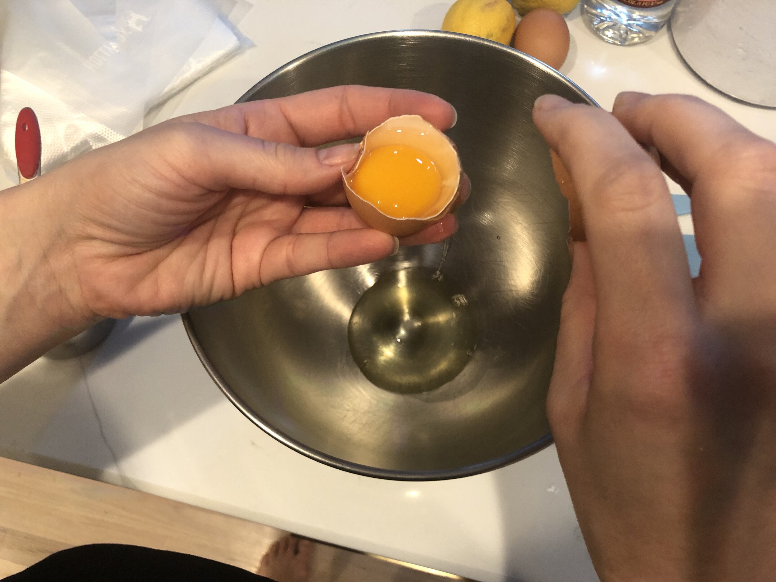  You can also use a tool or just your hands. The key is that NO YOLK get into the bowl. It will ruin the icing.  *Shoutout to my sweet husband for taking these egg separating pictures.  