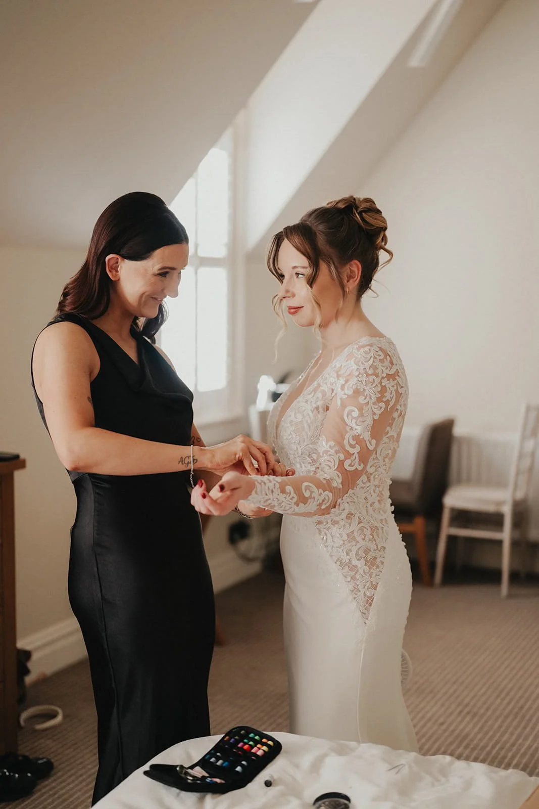 bridesmaid-helps-bride-with-dress.jpg