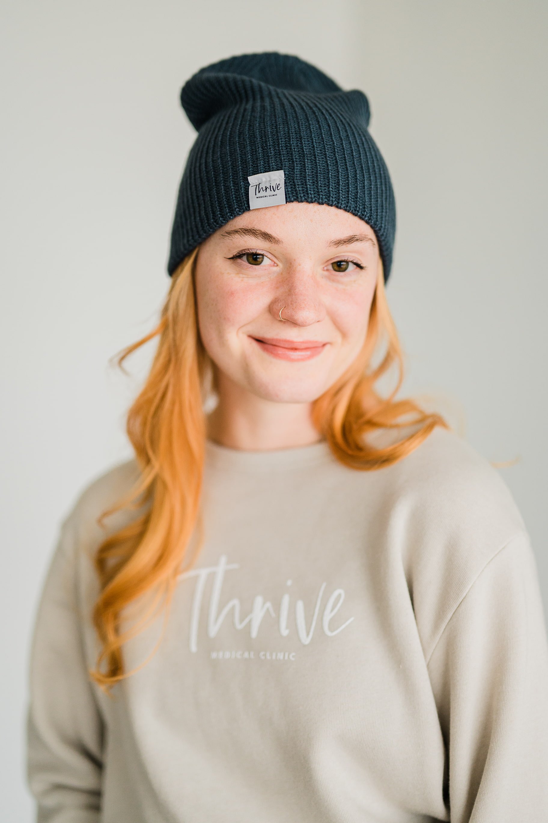 woman wearing beanie smiling at the camera