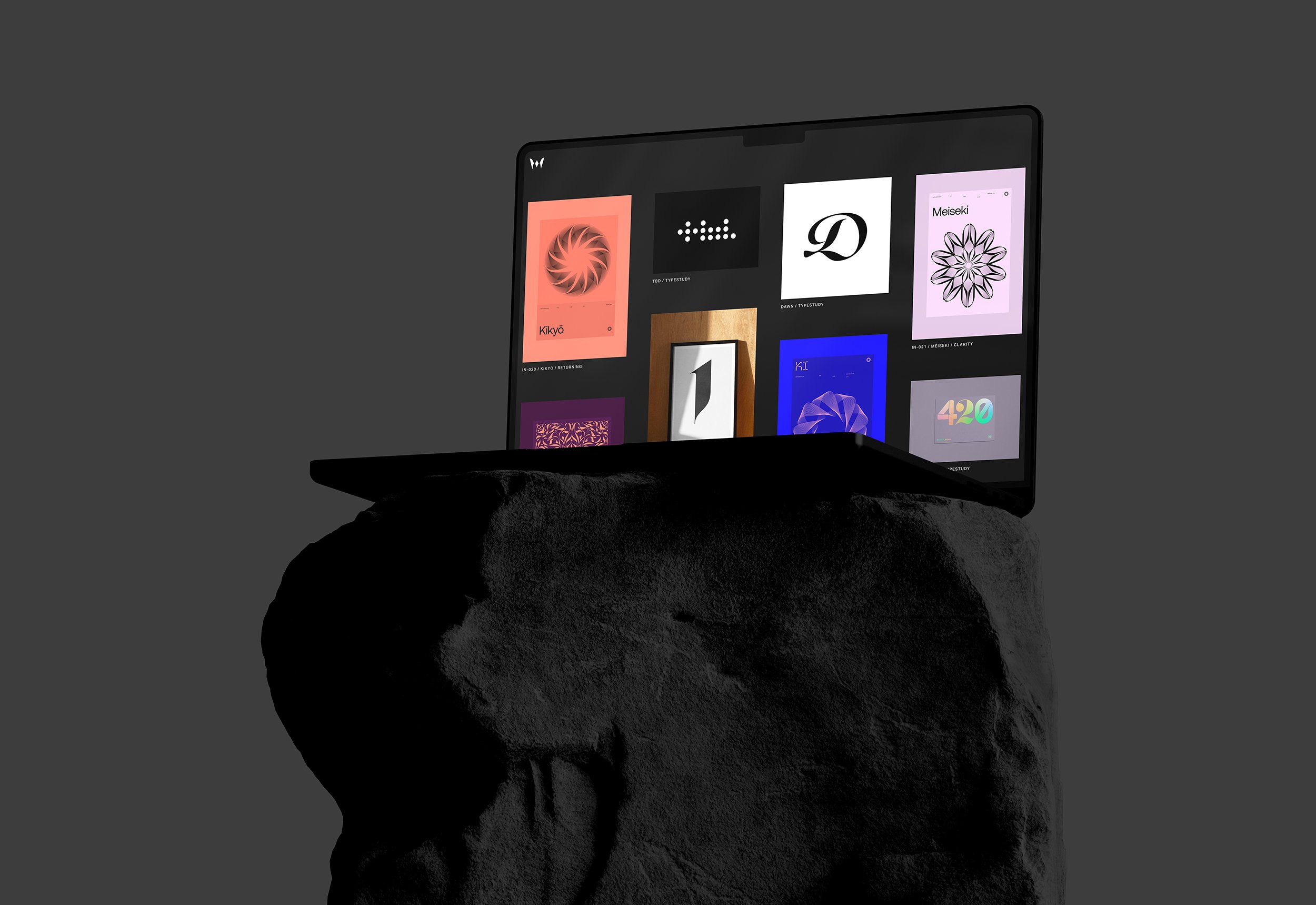 A digital tablet with various colorful app icons on the screen, placed on a rough, black stone surface against a dark background.