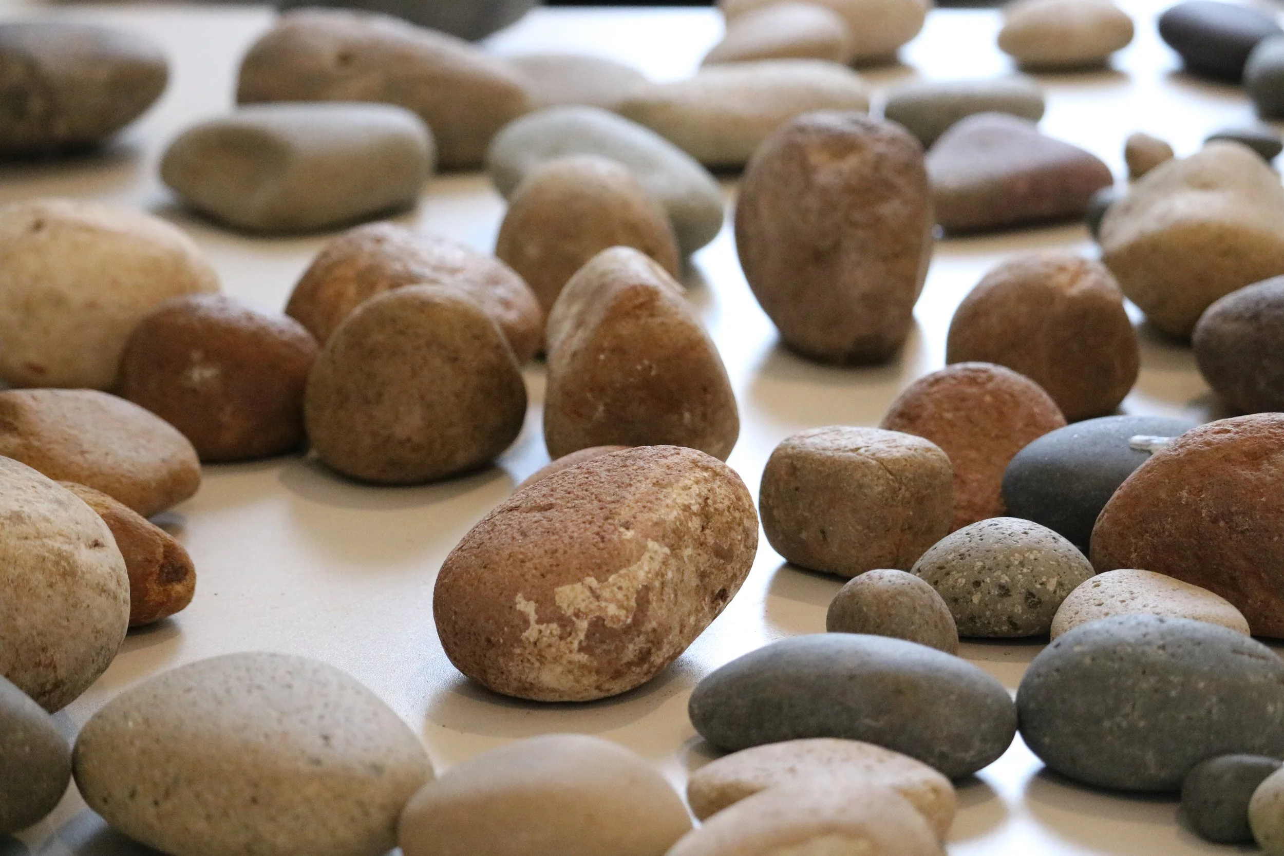  Rocks serve as anchor points within our landscape and are small capsules of earth and minerals that have been formed over time, affected by surroundings. Historically, they have been used as markers, molded into tools, and collected as souvenirs.  