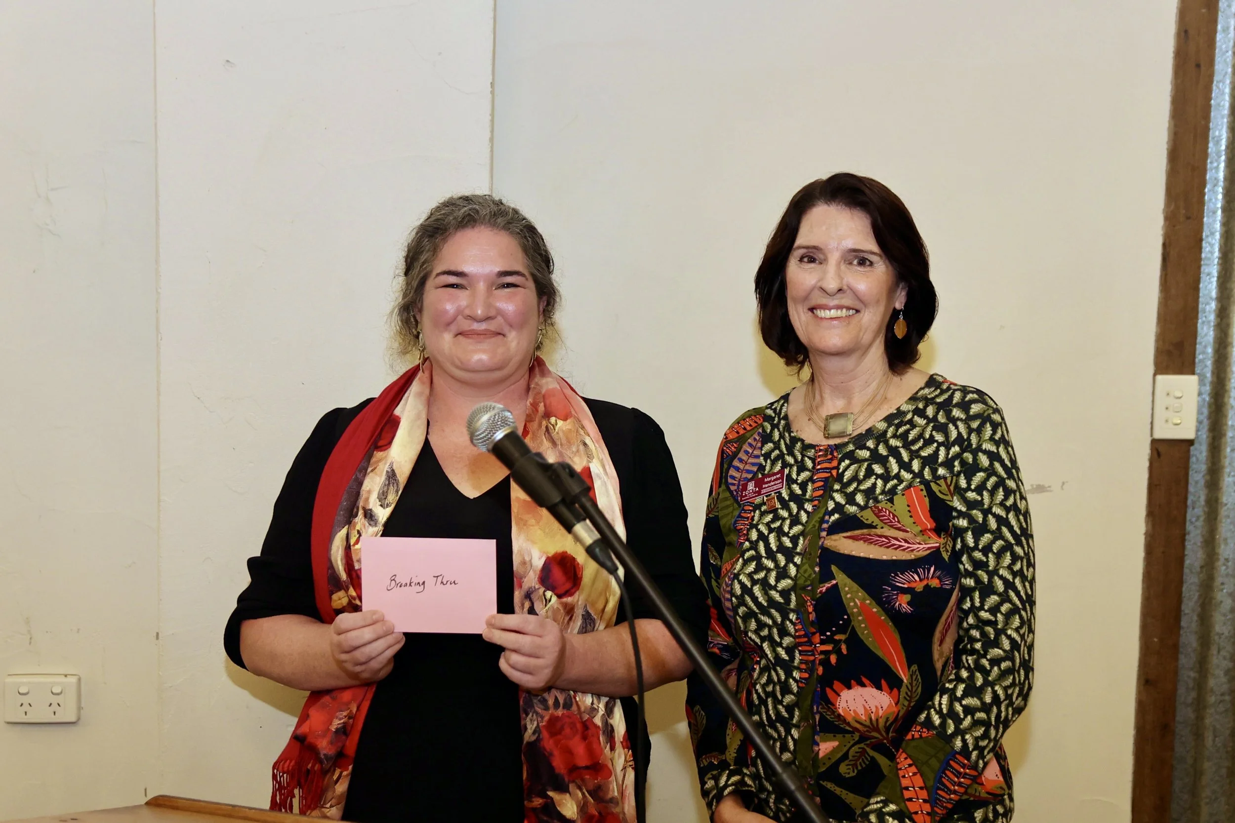 Breaking Thru founder Sarah Johnson accepts a donation from president Margy Henderson.