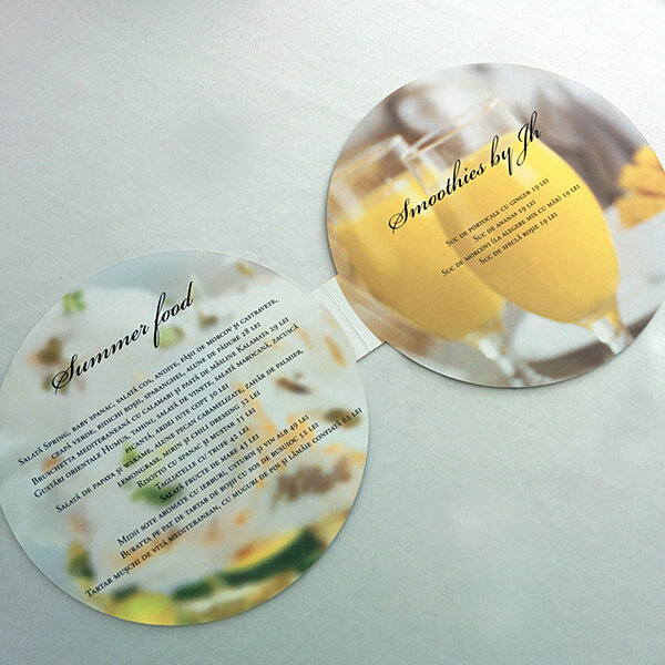 Two round menu cards on a white surface, one titled "Summer Food" and the other titled "Smoothies by JH," featuring images of mango smoothies.