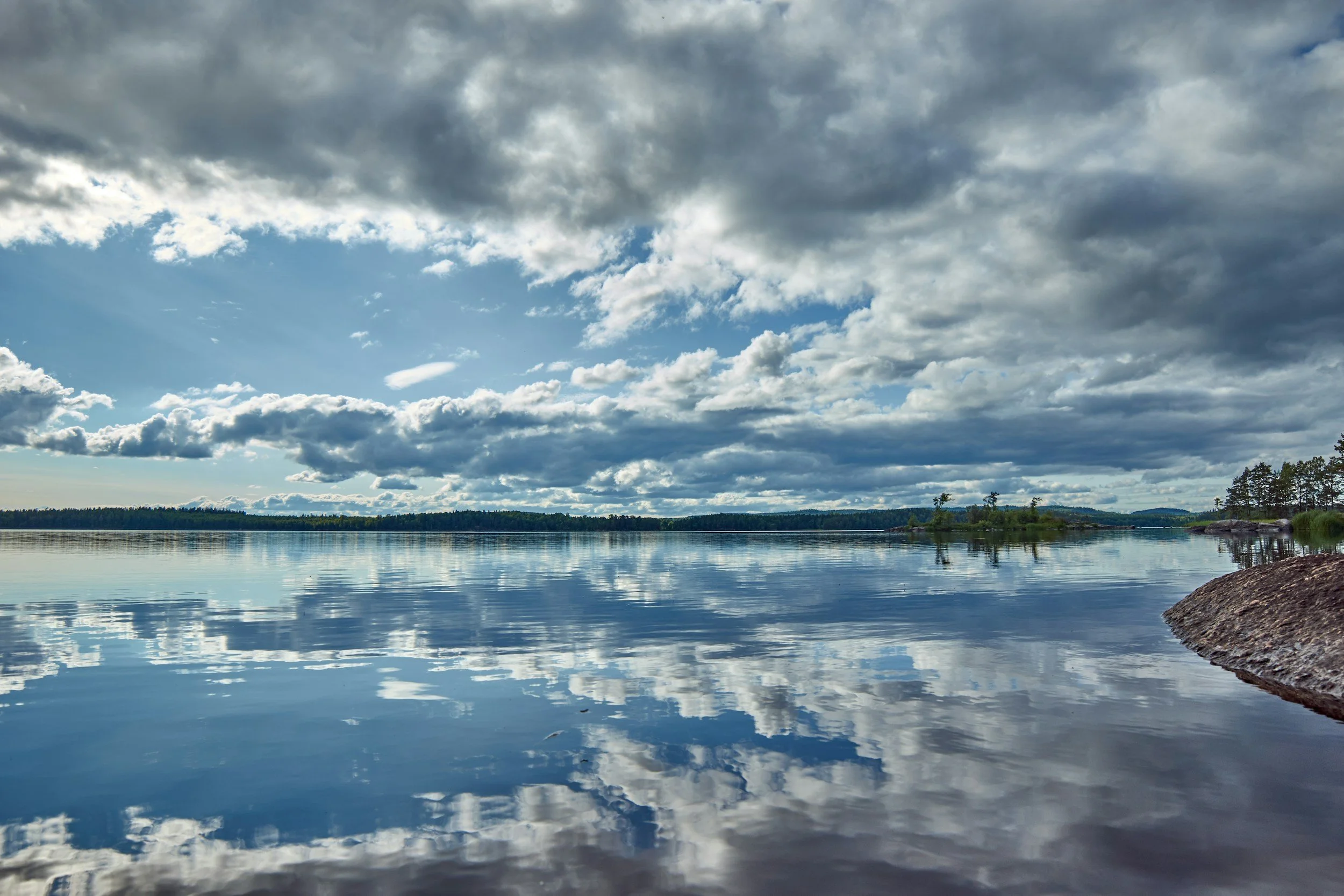 Calm lake reflecting sky after a storm, symbolizing healing from betrayal trauma for partners of compulsive sexual behavior