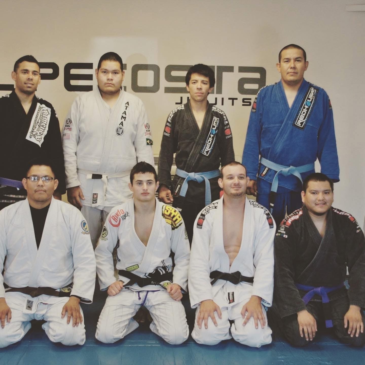 Red House Brazilian Jiu-Jitsu practitioners in gi uniforms posing in a martial arts dojo