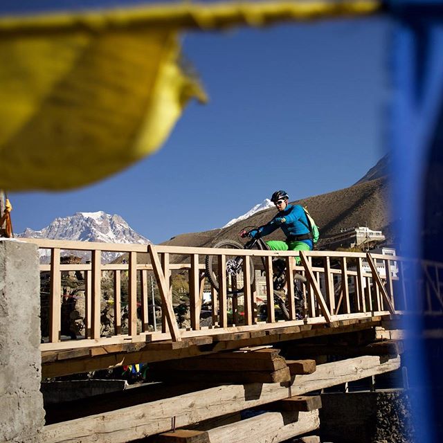 Wheelying on a wooden bridge across a glacial stream while protected by a string full of Buddhist prayer flags. This is Nepal. 📸: Fabian Gleitsmann

#nepal #himalayas #mtb #mountainbike #adventure #photography #himalayanrides #mustang #yeticycles #t