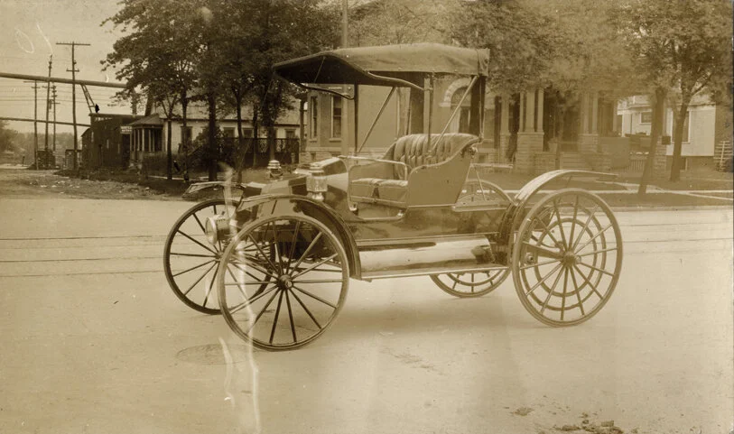 A motor buggy around 1914. The Lee Mansion’s original open-air porch can be seen in the background.