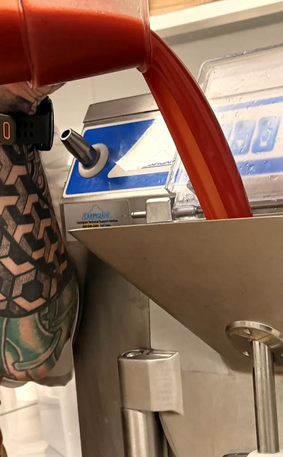 Strawberry base being poured into the batch freezer