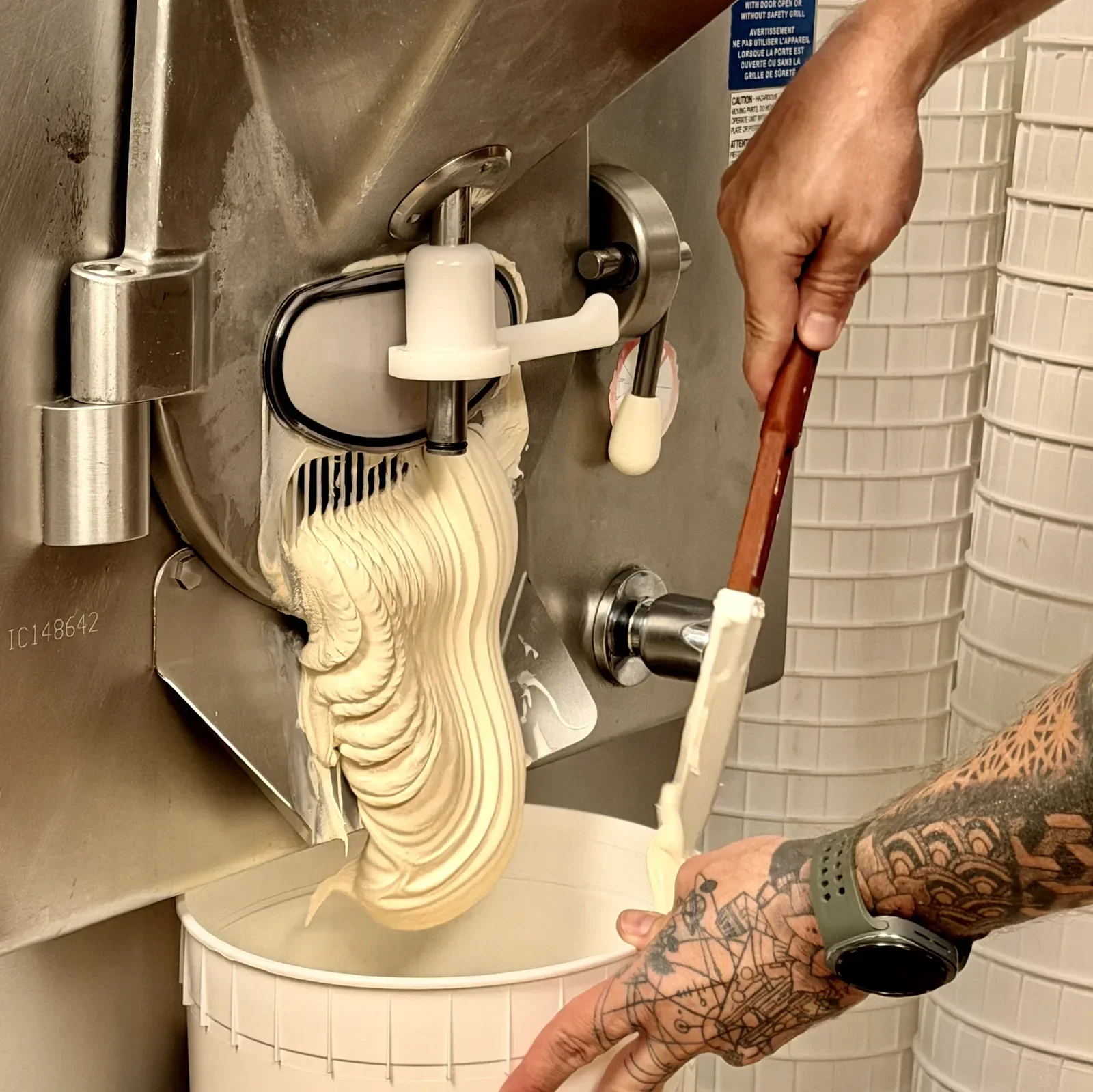 Vanilla ice cream ribboning out of the batch freezer