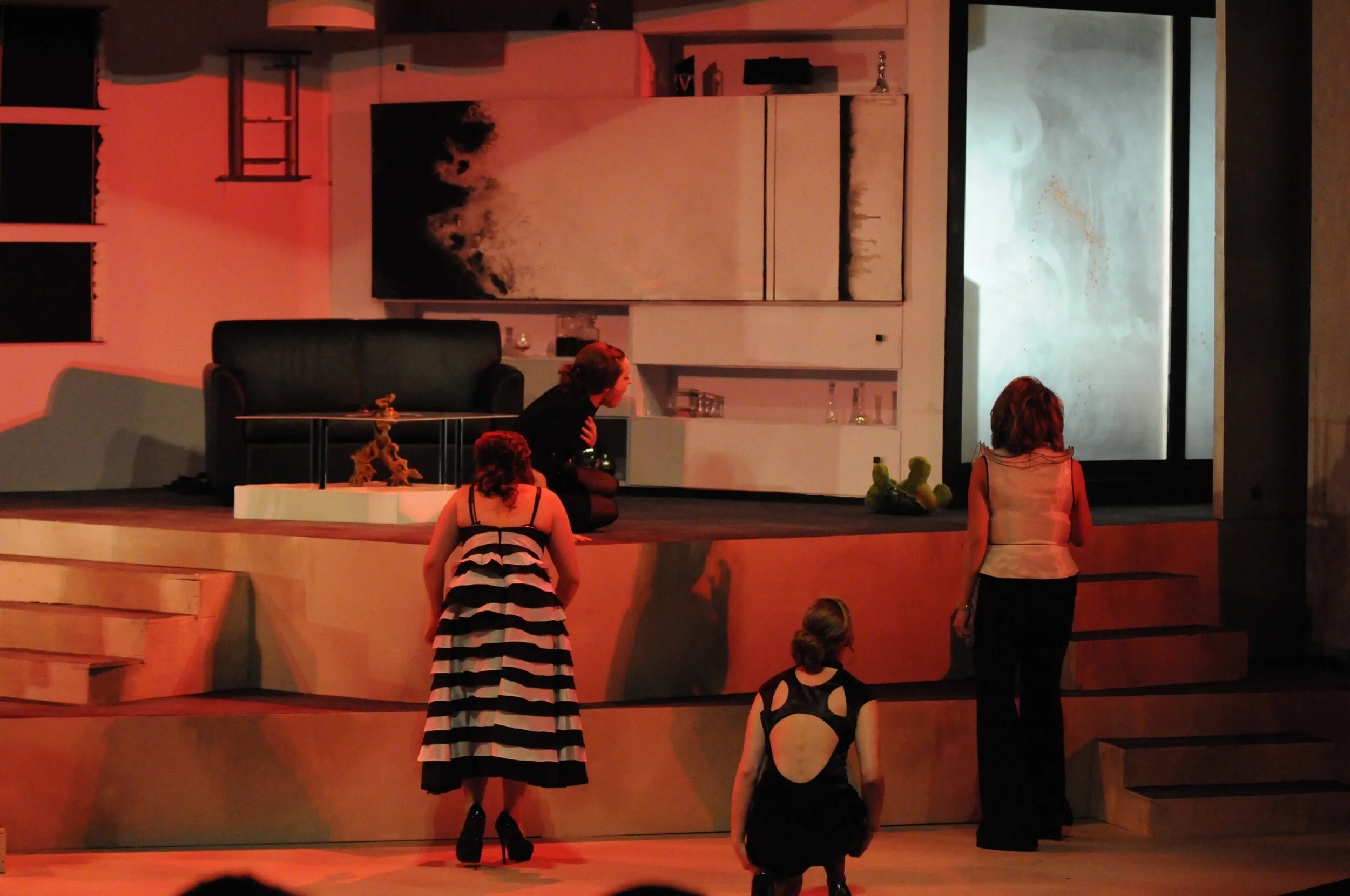   Chorus members before blood splattered frosted glass wall  