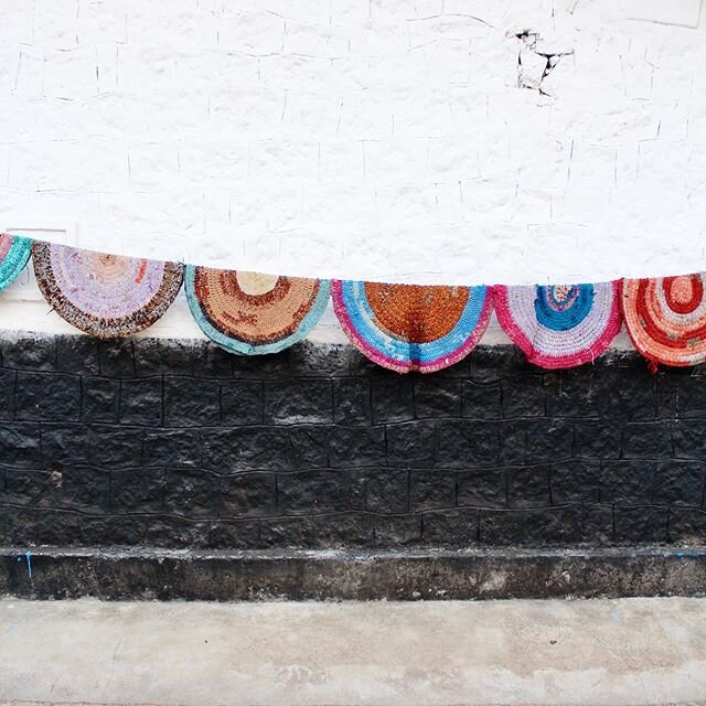 On a walk I saw these hand made rag rugs, crocheted? Hanging  to dry on a village house wall in Munnar, Kerala.