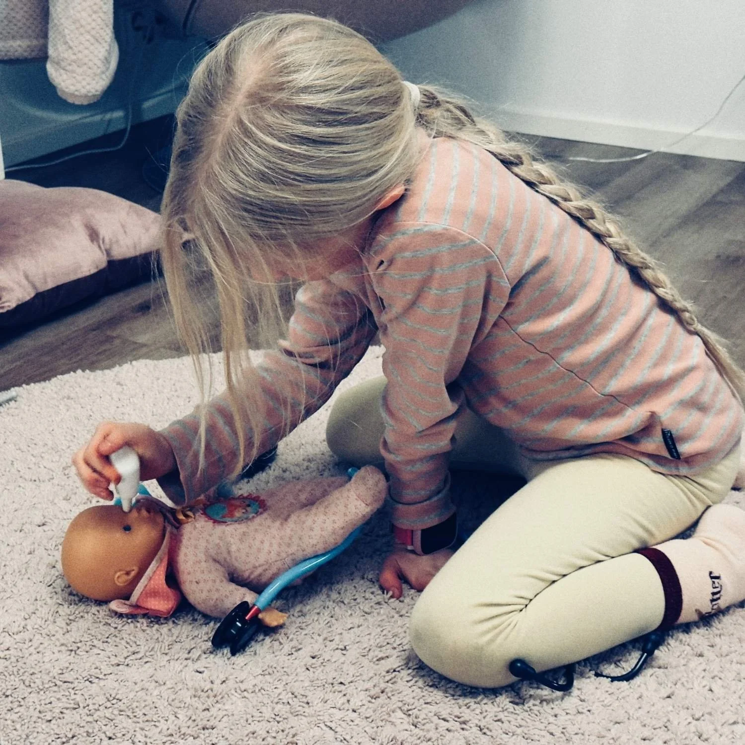 Kuvassa lapsi leikkii lääkäriä ja tutkii vauvaa.