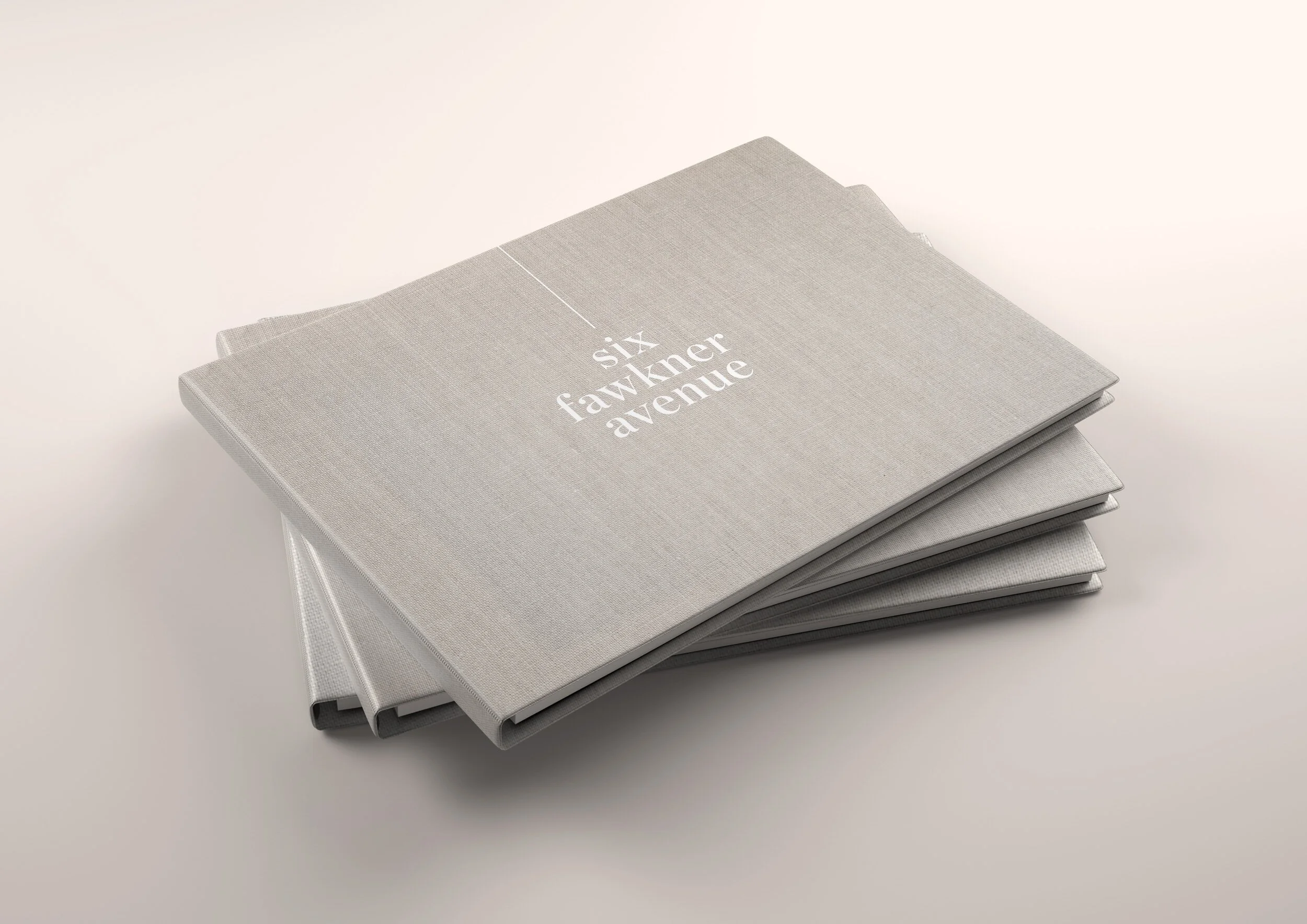 Stack of three grey hardcover books, with the top book titled 'six fawcner avenue' on a plain white background.