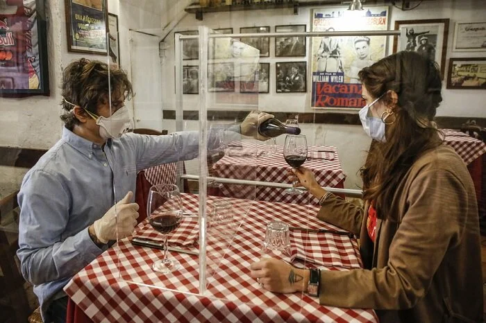 A cena, ma col plexiglass