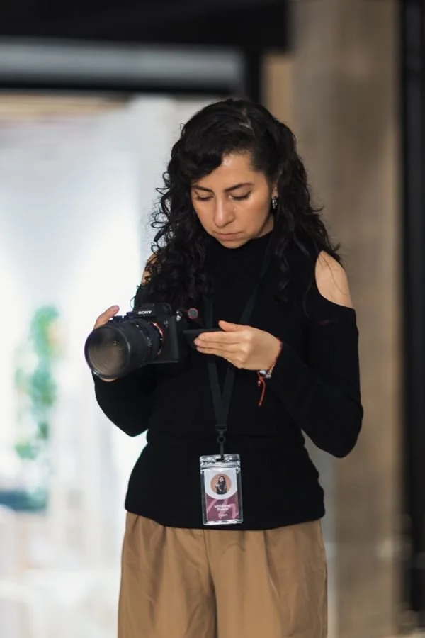 Photographer reviewing camera settings for portraits on the camera LCD in aperture priority mode