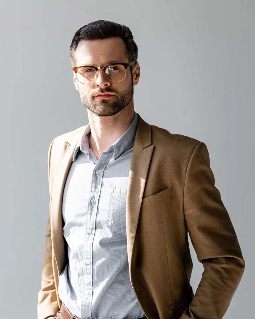 Handsome businessman in glasses looking at the camera