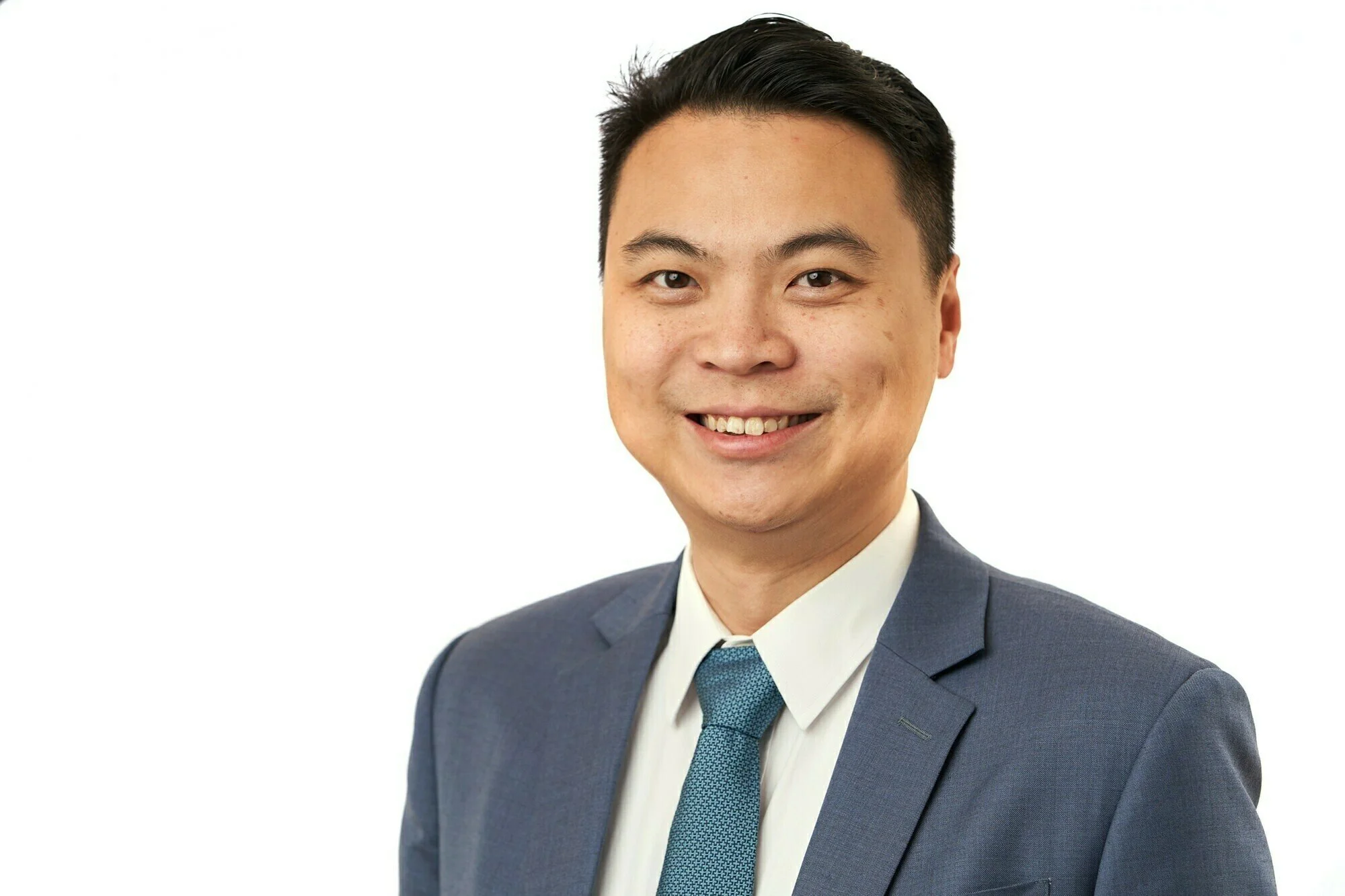 Corporate headshot of an Asian businessman against a white background