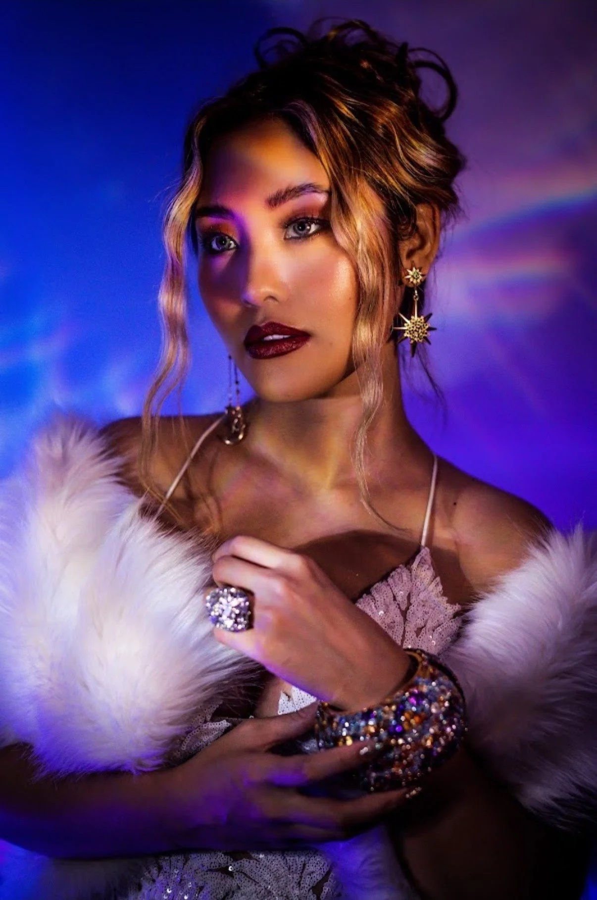 Model wearing a statement ring, starburst earrings and jeweled bracelet in a dramatic jewelry editorial by David Christopher Lee
