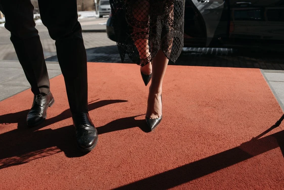 Stylish couple posing on a red carpet at a Los Angeles premiere