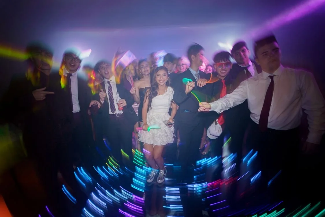 Teenagers celebrating on a dance floor with colorful party lights at a bar mitzvah in Los Angeles