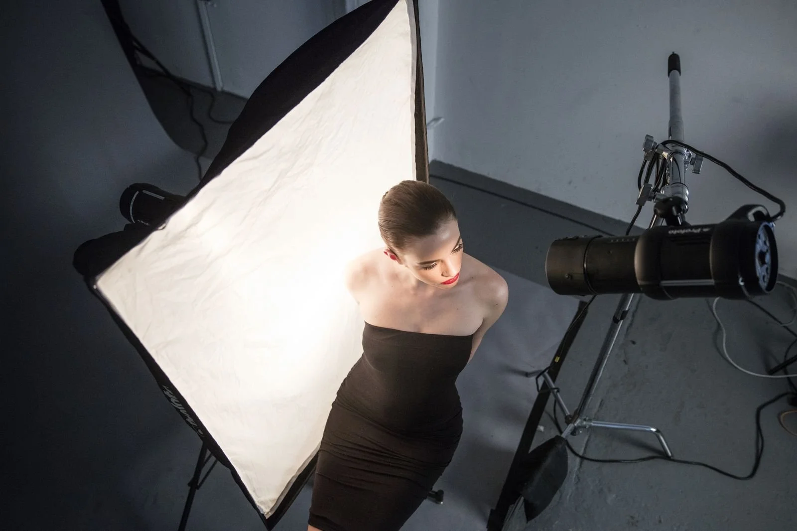 Behind the scenes of a studio portrait shoot with a strobe light and large softbox, the classic strobe vs continuous lighting studio setup