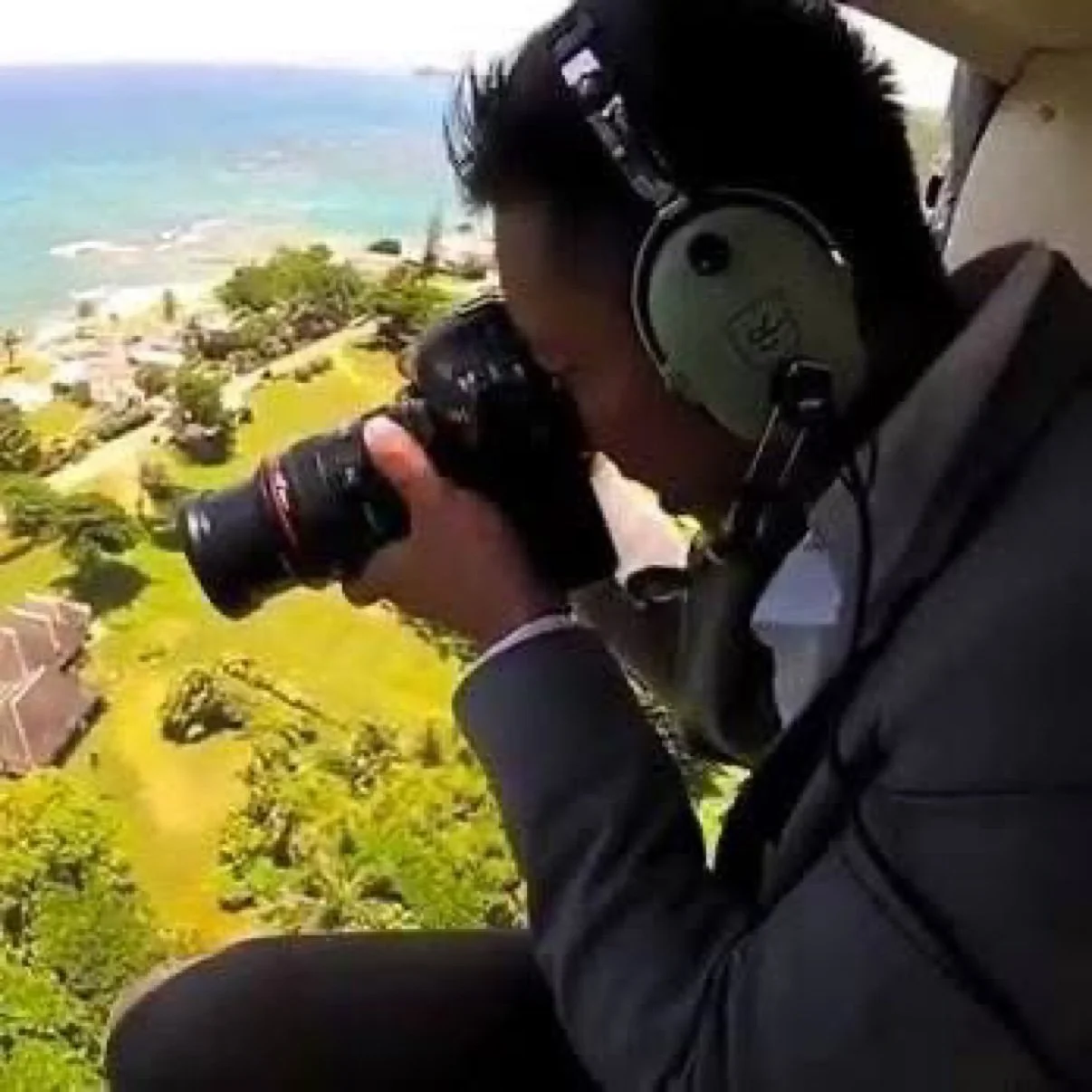 David Christopher Lee photographing from a helicopter with his camera on an assignment shoot