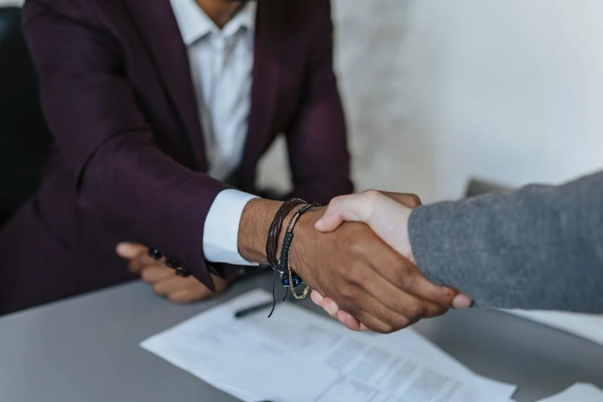 Business handshake over a signed contract: what a professional corporate photographer puts in writing