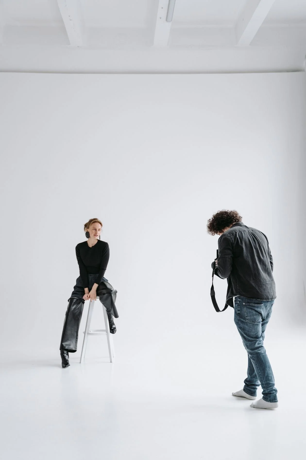 Fashion photographer working with a model on a white cyclorama in a Los Angeles studio