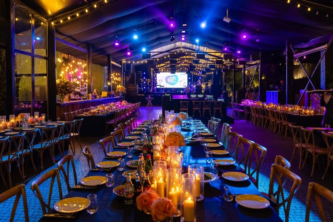 Elegant candlelit tables set for a charity gala dinner in Los Angeles