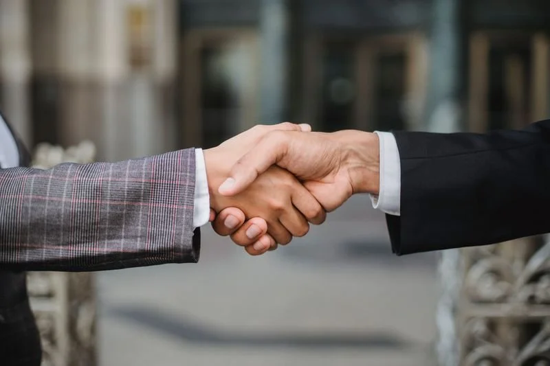 Two people shaking hands after signing a photography contract