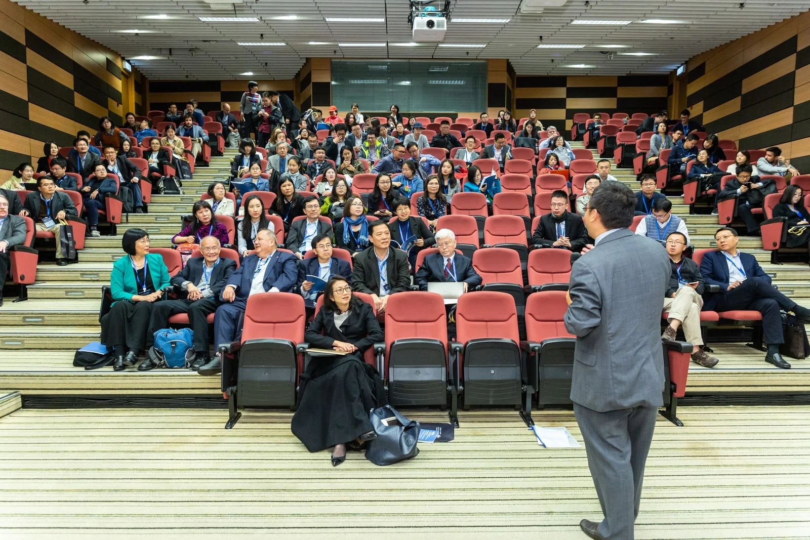 Business conference audience with speaker on stage, photographed by an experienced corporate photographer