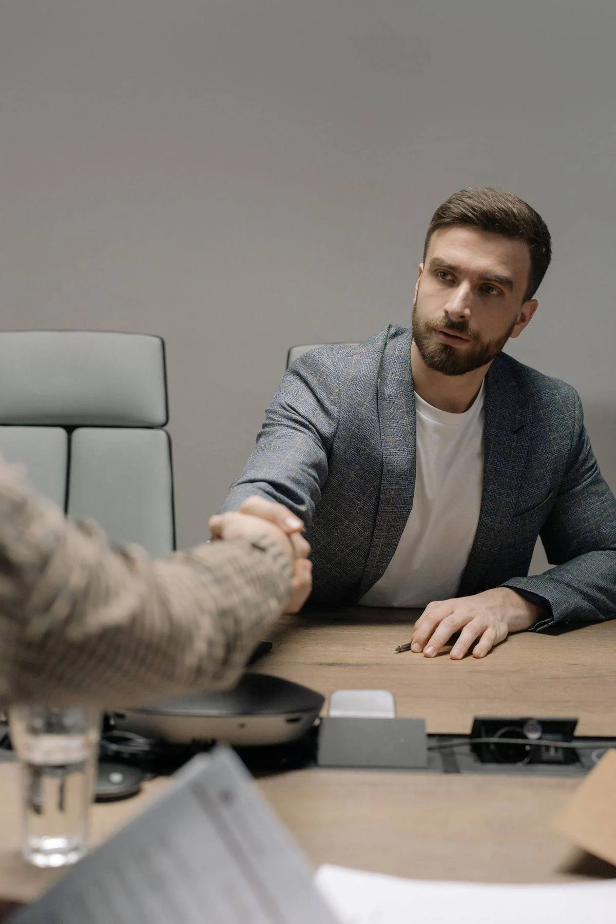 Photographer shaking hands with a new client during a booking meeting, how photographers get clients through trust and referrals