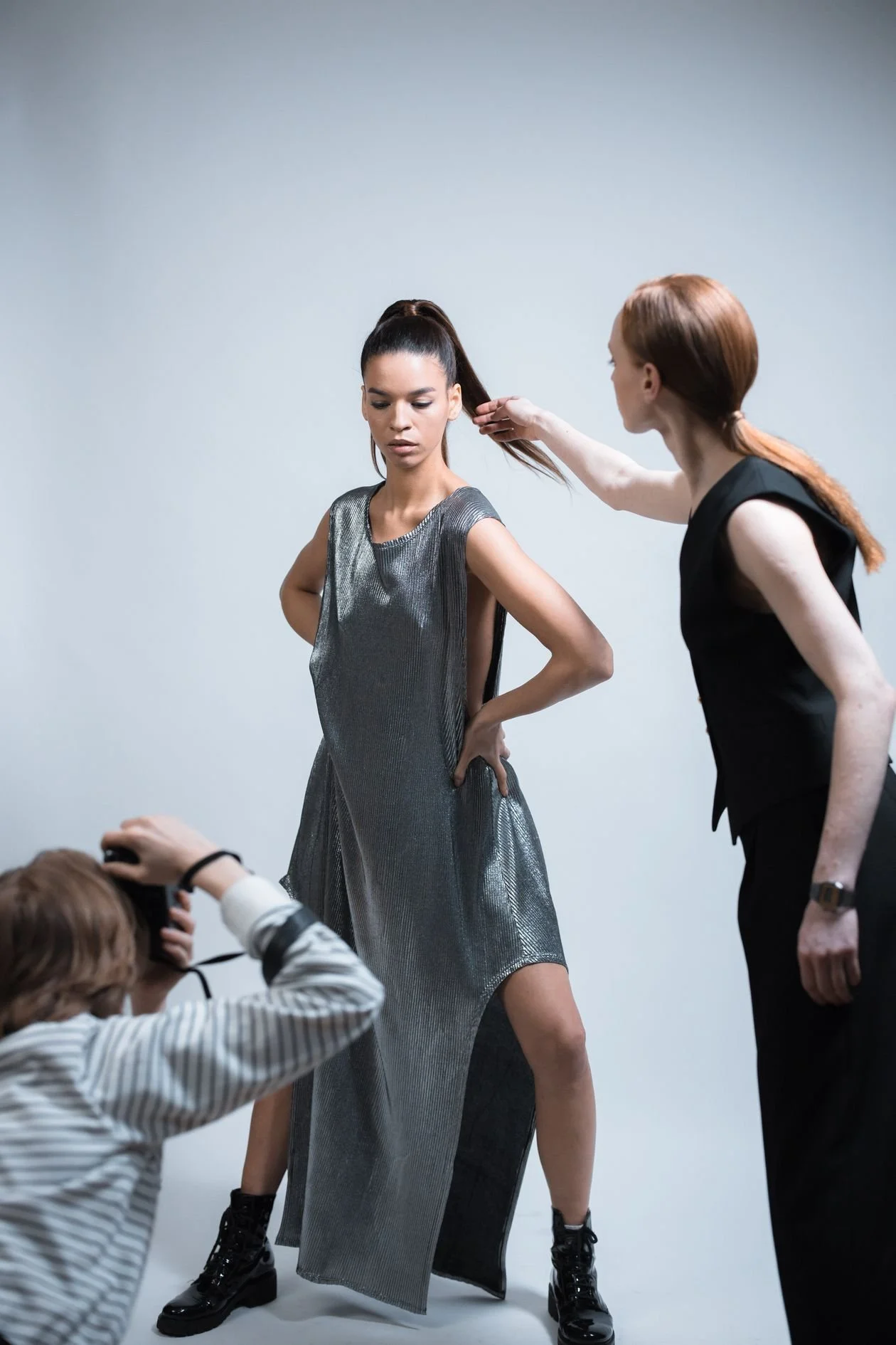 Stylist adjusting a model's hair on a Los Angeles fashion shoot while the photographer works